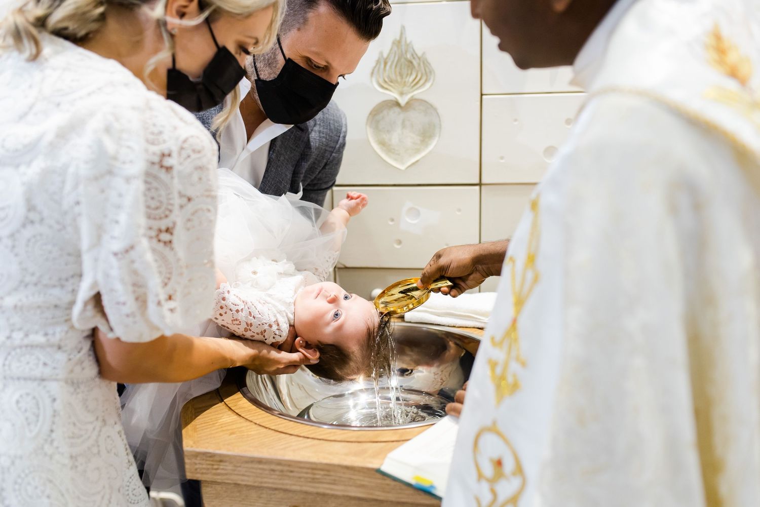 A religious baptism ceremony being performed at a church font.