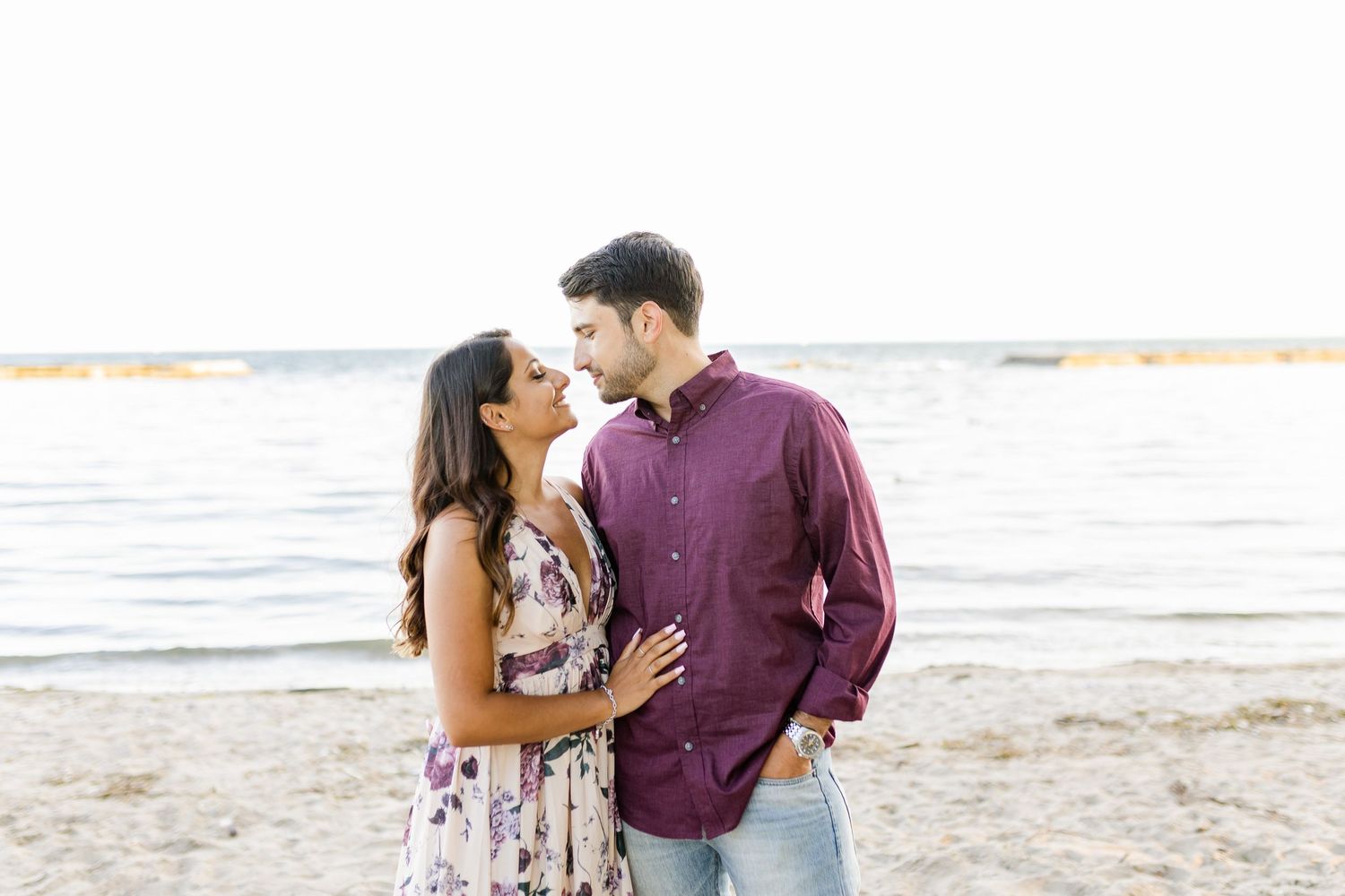 A romantic couple shares an intimate moment on a beach at sunset.