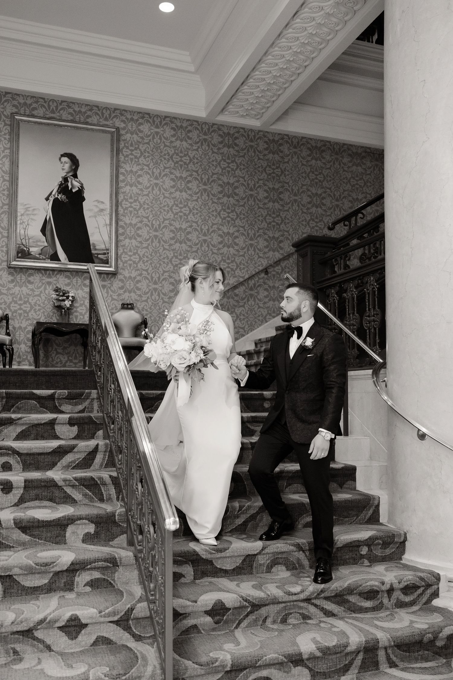 A wedding couple ascends an ornate carpeted staircase in a series of sequential black and white photos.