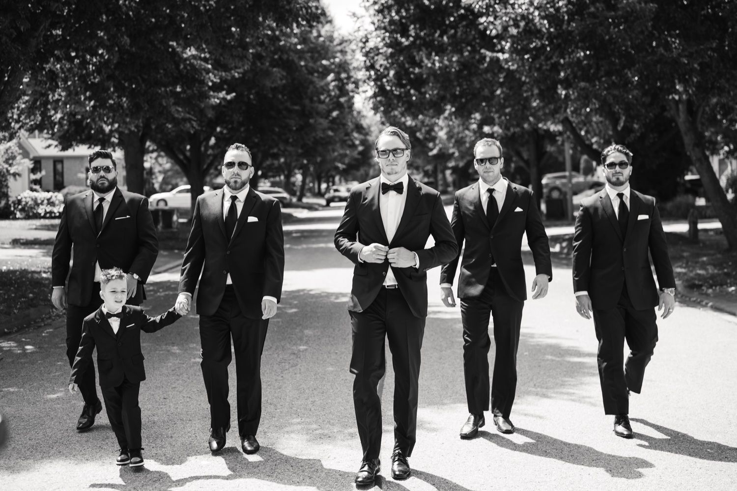 Black and white photo of groomsmen walking together on wedding day.