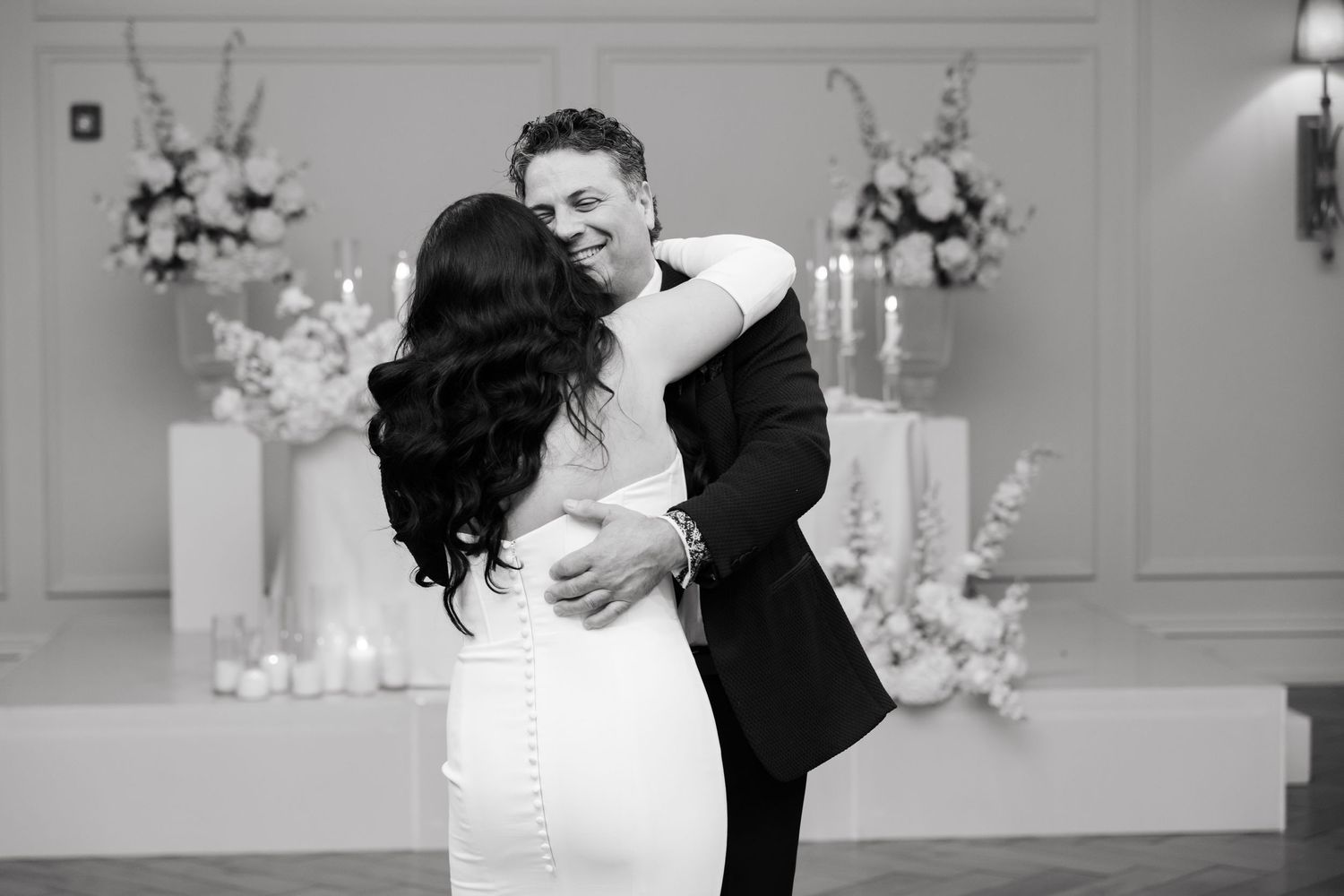 A black and white capture of a romantic dance moment at an elegant wedding reception.