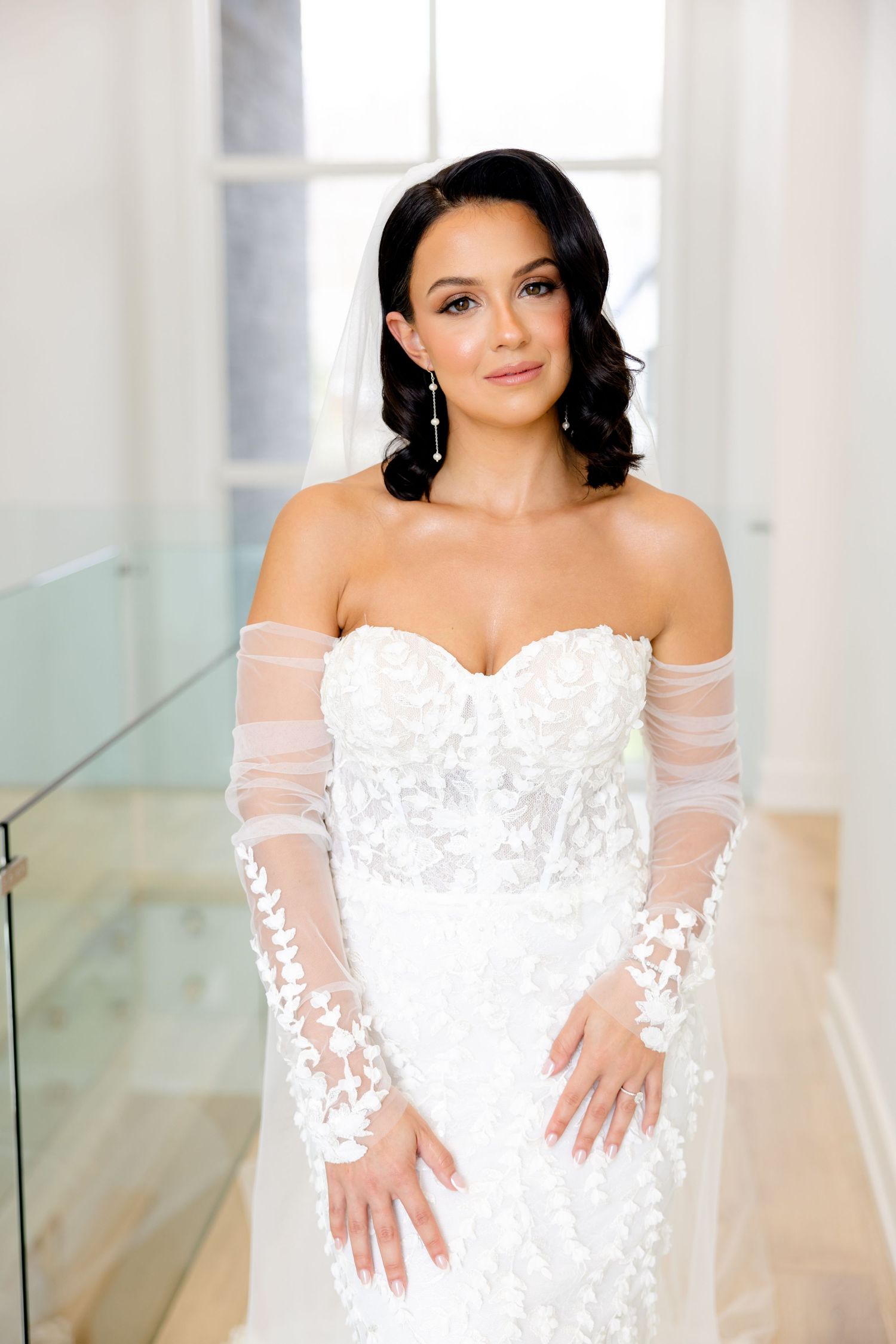 Elegant bridal portrait featuring delicate off-shoulder sleeves and detailed lace bodice wedding gown.