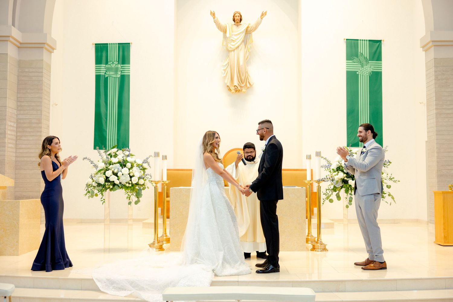 Traditional church wedding ceremony with elegant decor and white floral arrangements at the altar.