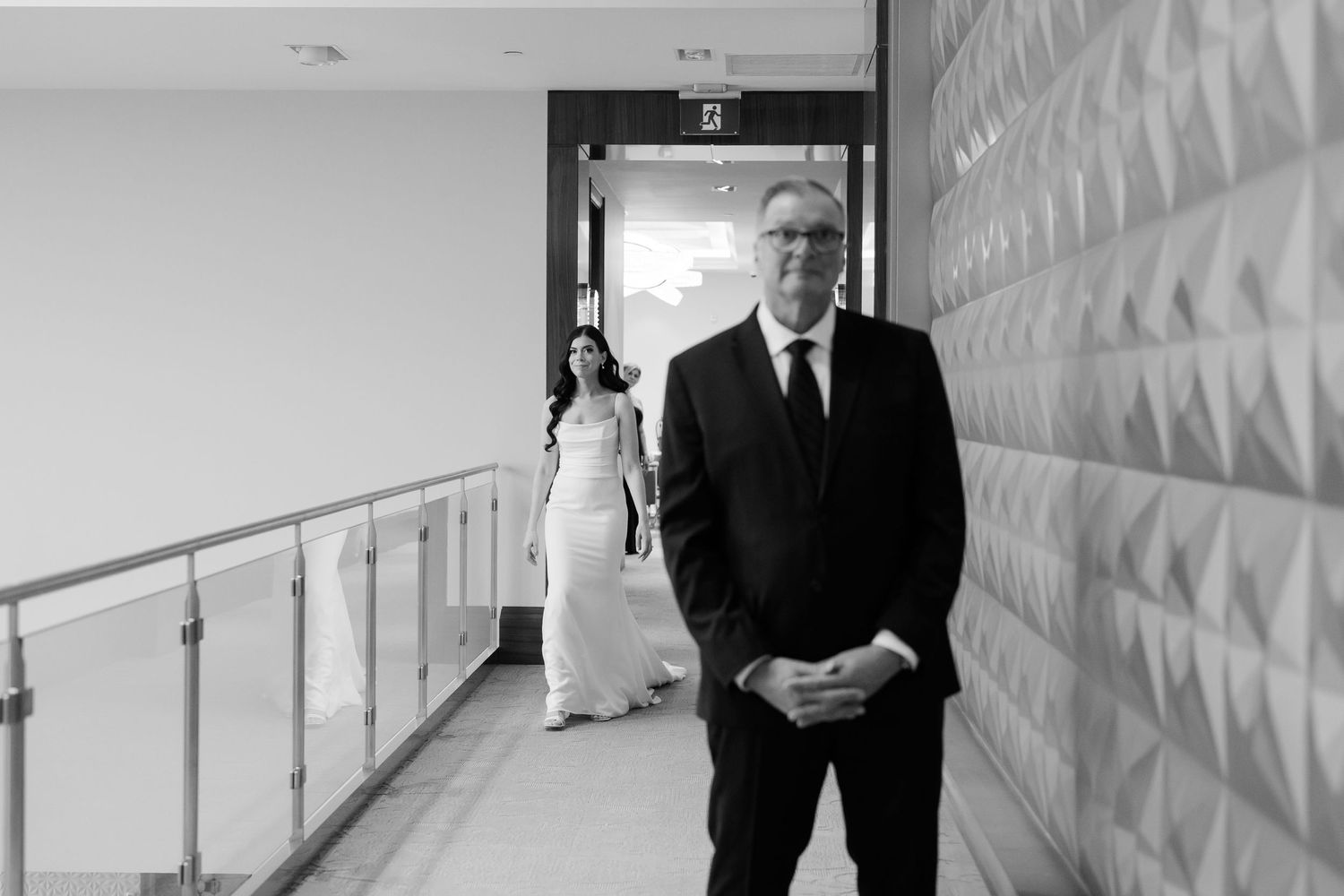 Black and white hallway shot of formal wedding day preparations.