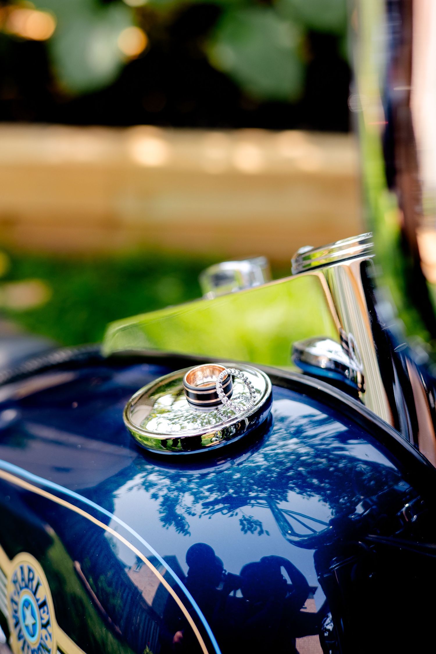 Close-up detail of vintage motorcycle fuel tank with chrome accents and blue paint.