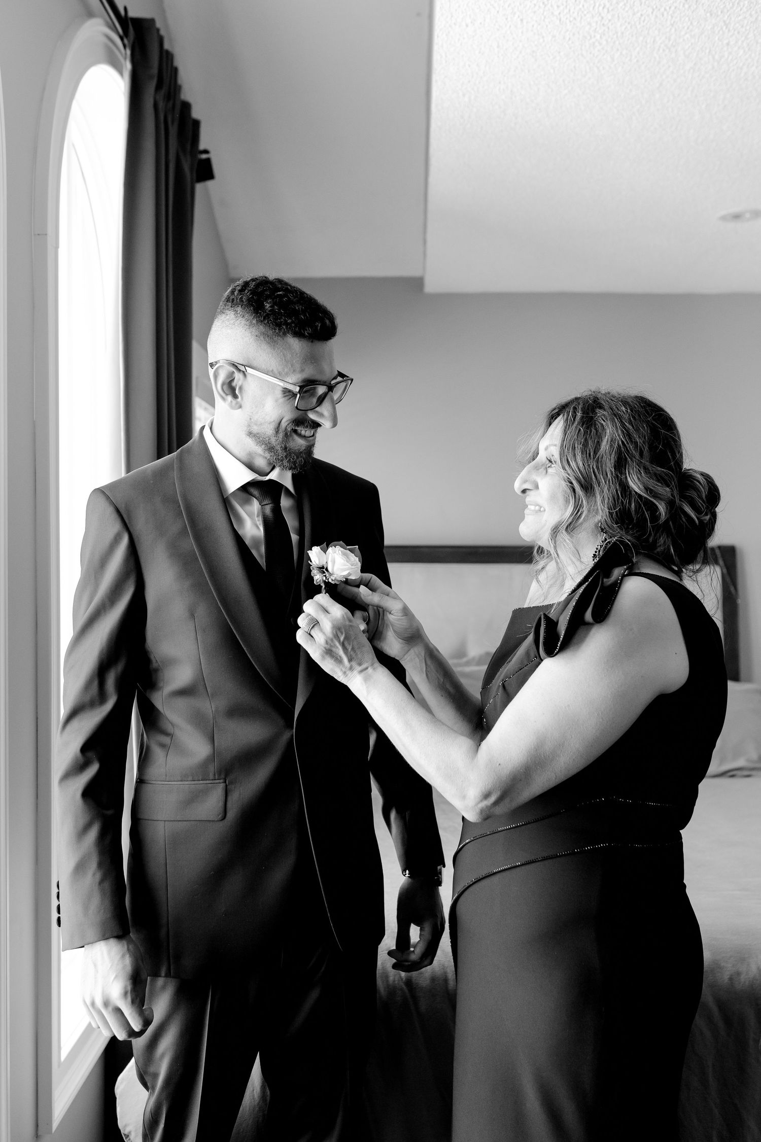 A boutonniere being pinned on during formal event preparations.
