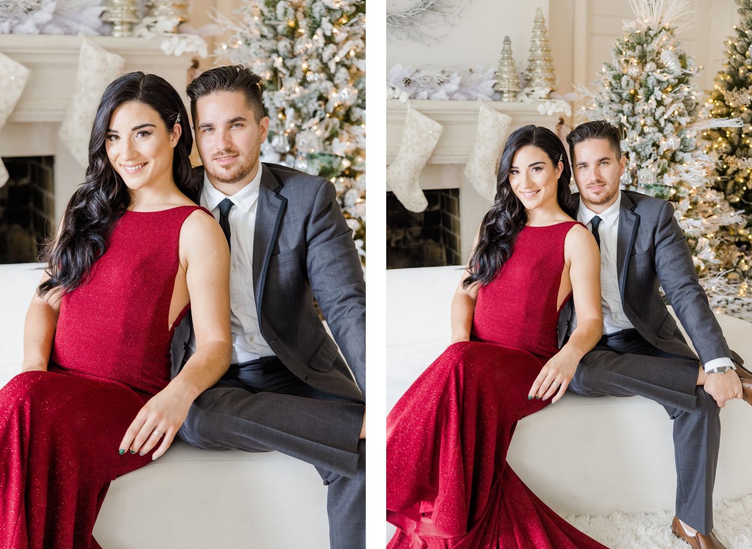Elegant couple poses in red dress and grey suit against decorated Christmas trees and fireplace.