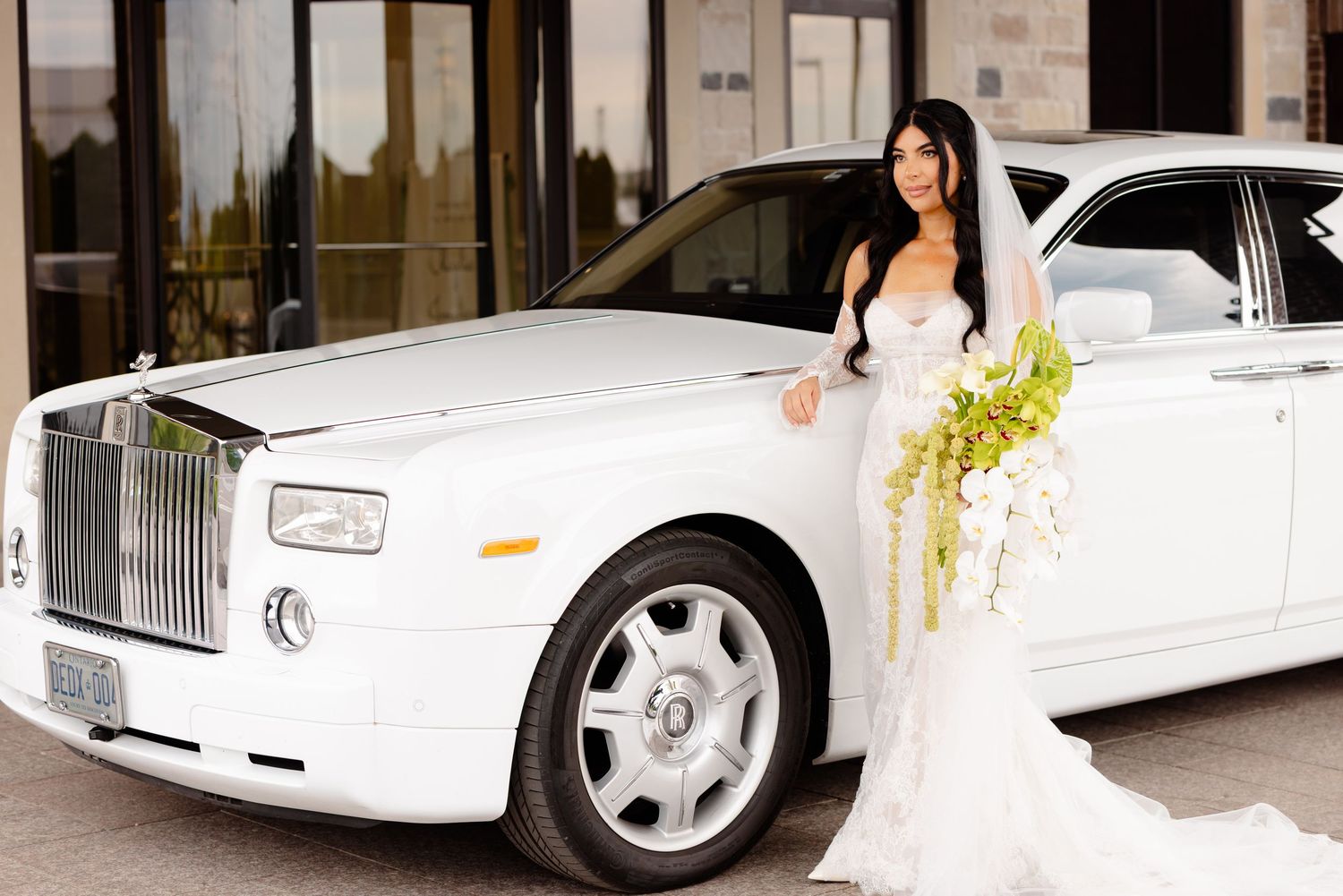 White stretch limousine parked outside a building with elegant decor for a special occasion.
