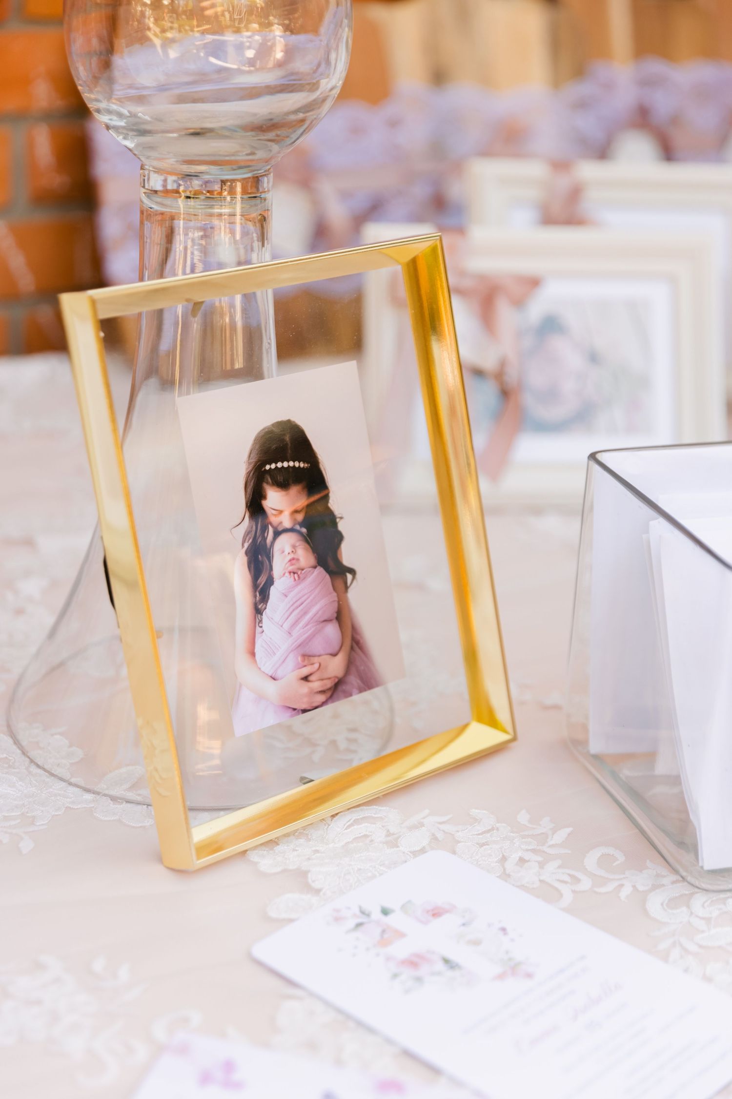 Gold-framed photograph displayed on an elegant table setting with glassware.
