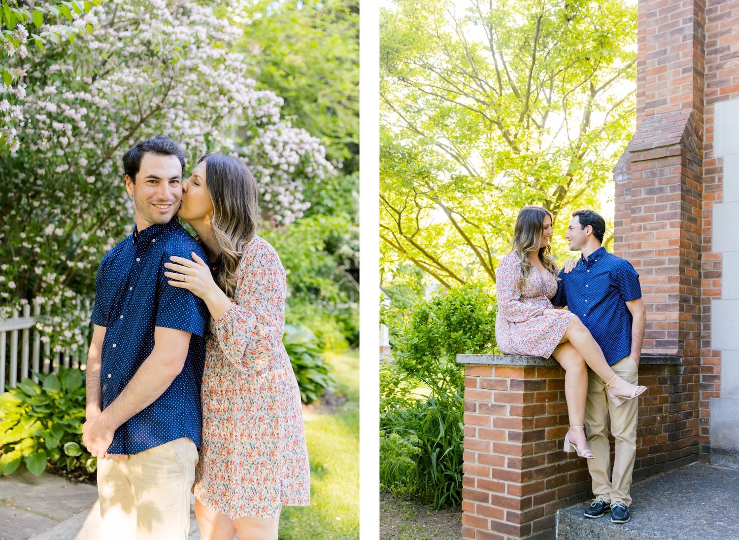 A couple poses playfully against brick walls and flowering trees in a garden setting.