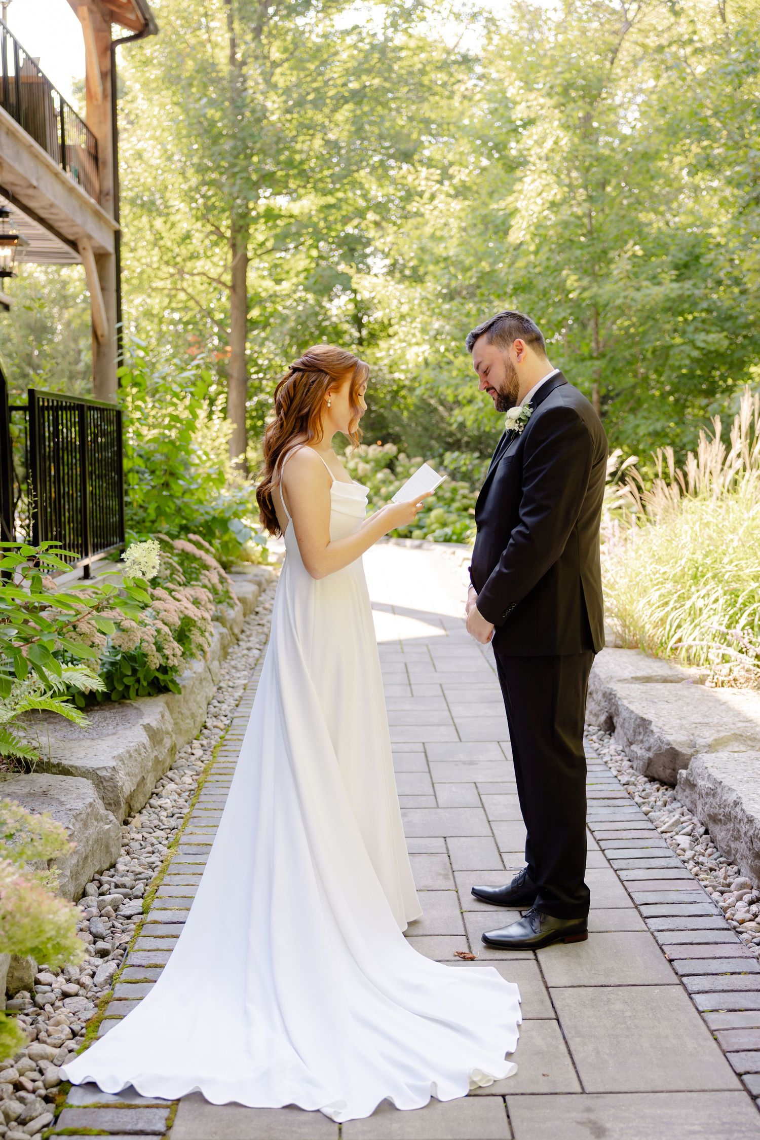 Wedding ceremony moment on a stone pathway with lush gardens and architectural details.