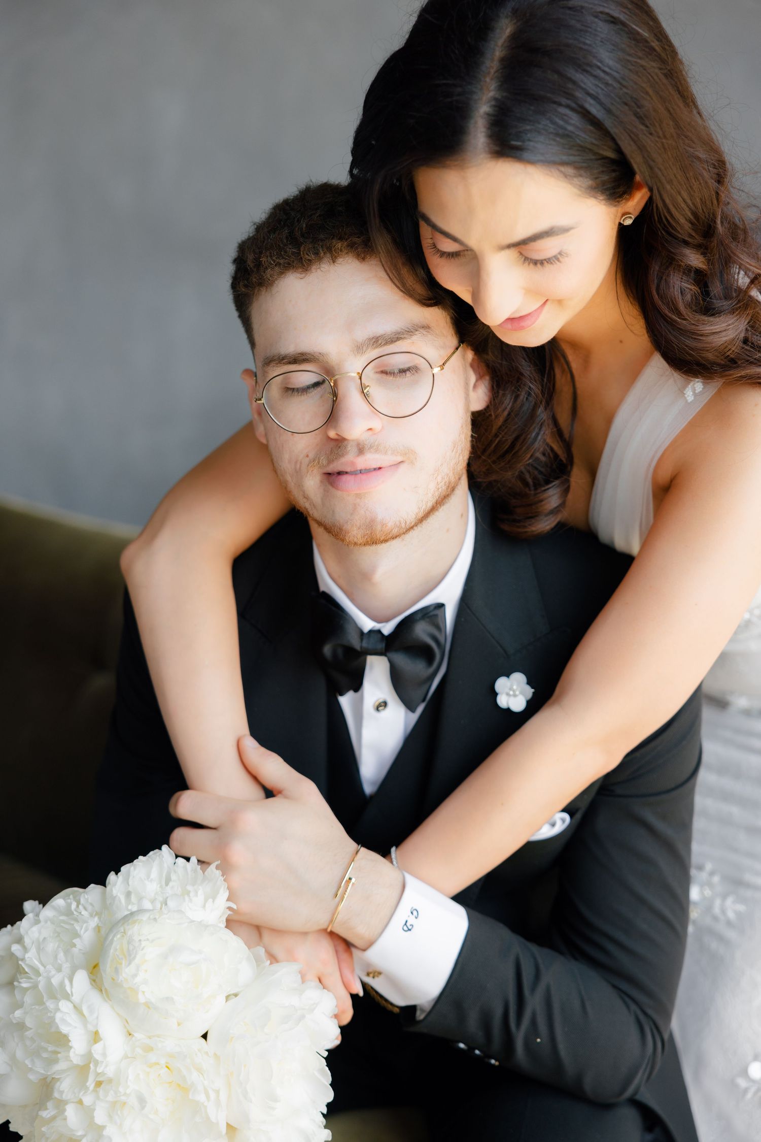 Romantic wedding portrait showing tender moment between couple with white bouquet.