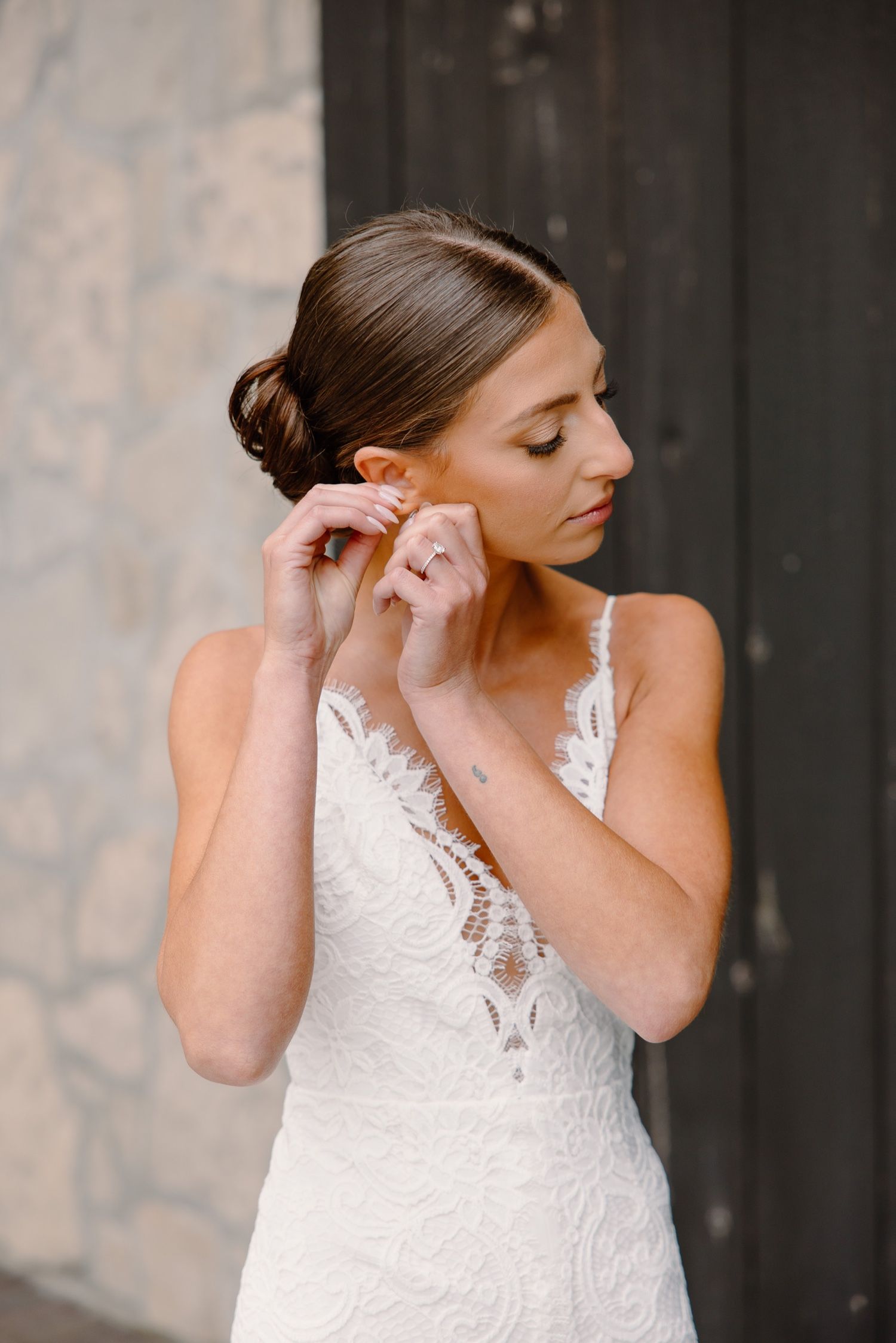 Wedding preparation scene with white lace dress detail against dark background.