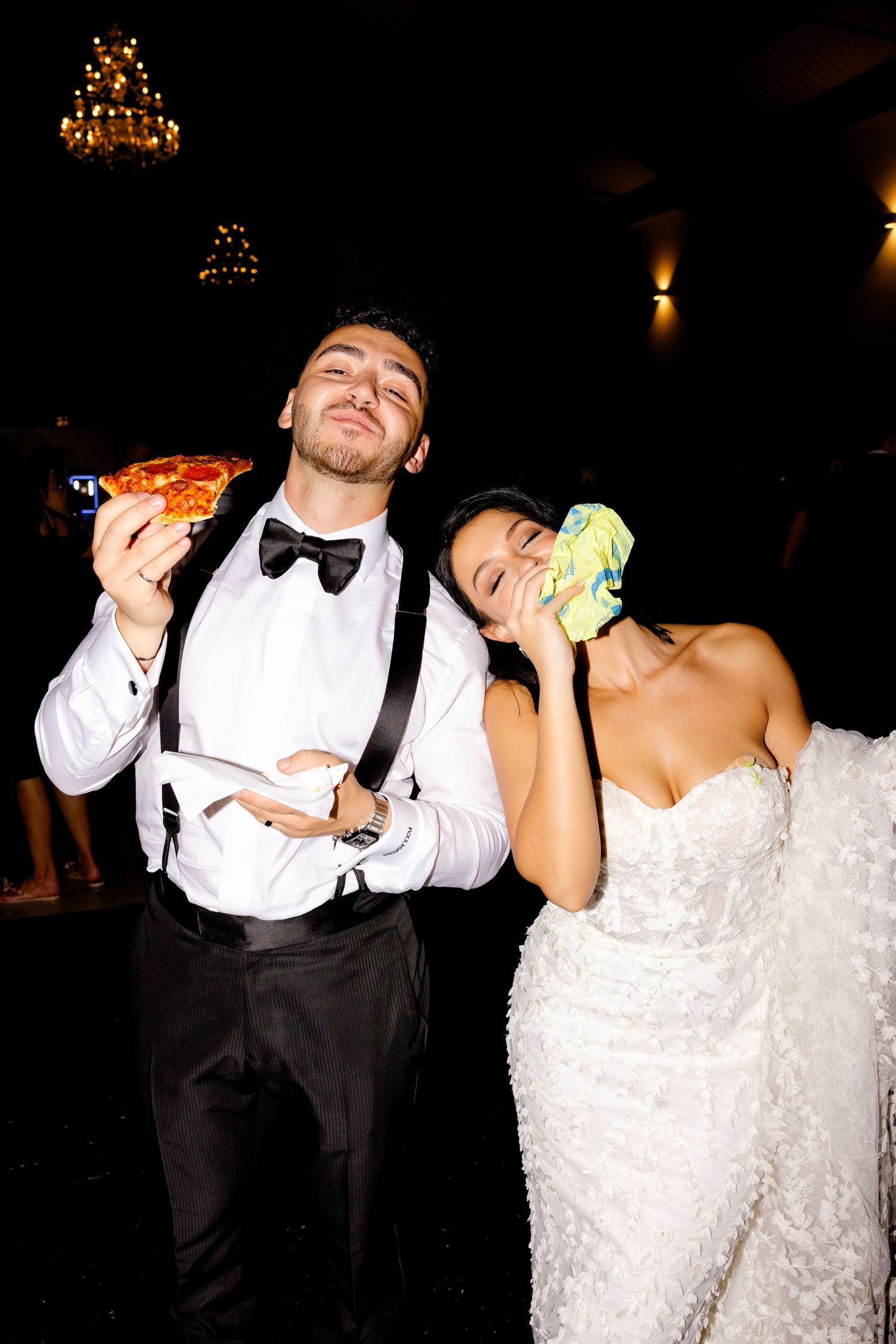 Wedding celebration with couple enjoying late night snacks and glowsticks at reception.