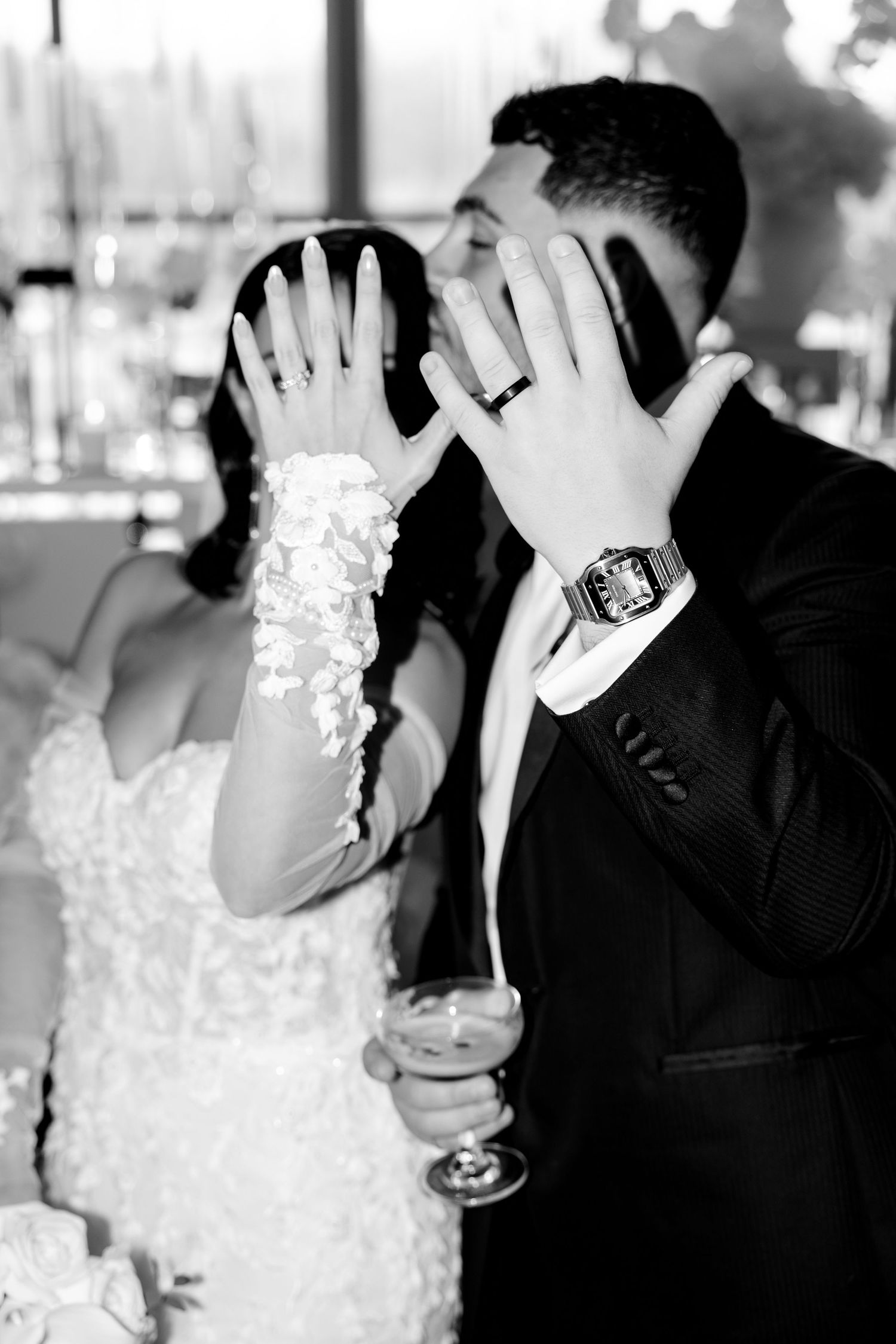 A black and white wedding photo showing rings and champagne glasses.