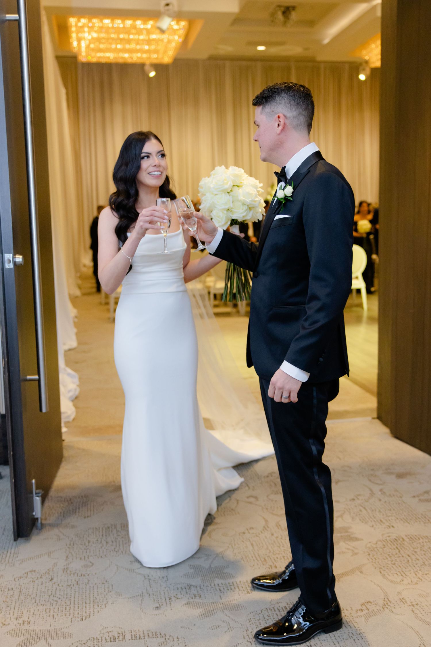 A couple celebrates with champagne in an elegant reception venue.