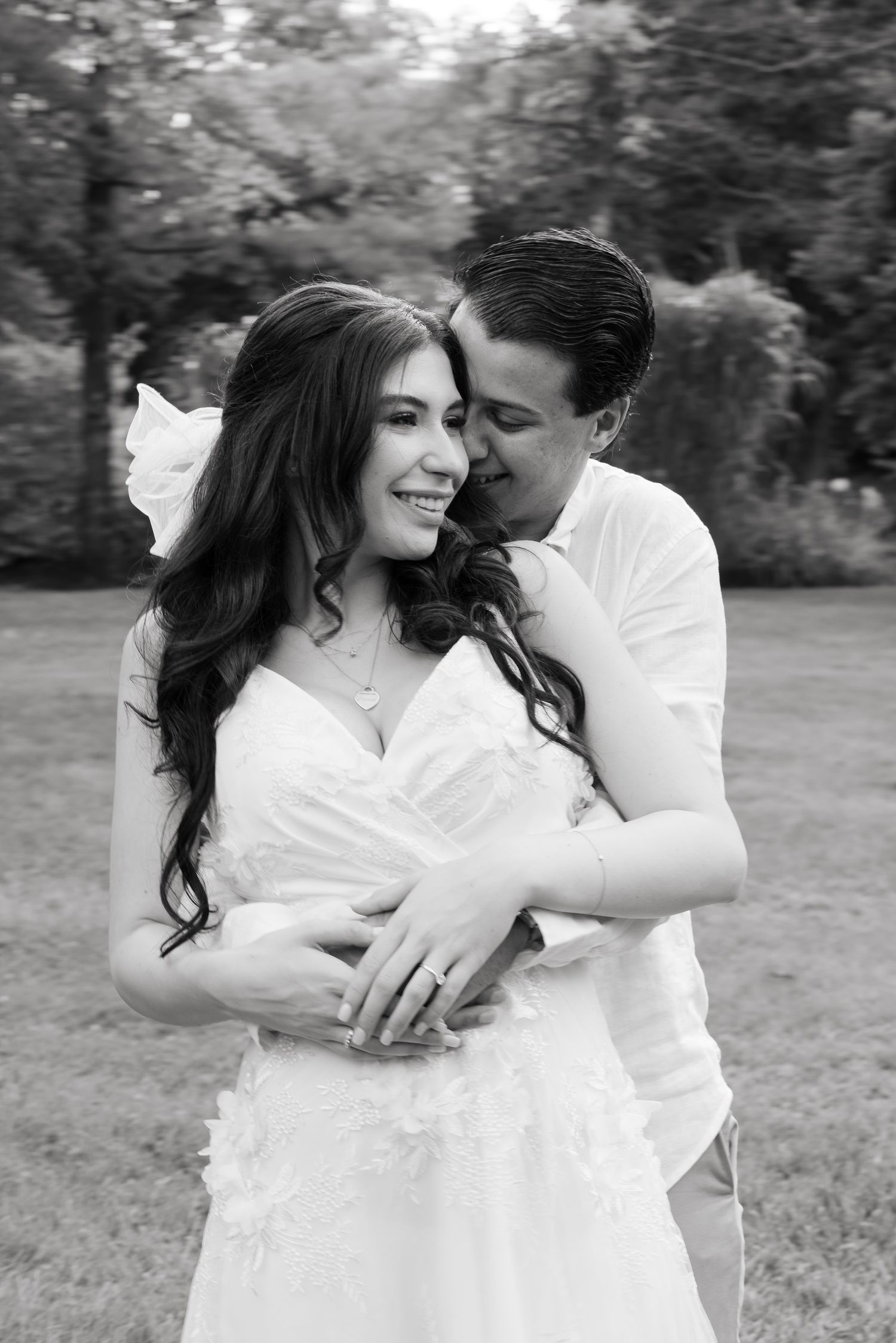 A romantic black and white portrait capturing an intimate moment between a couple dressed in white.