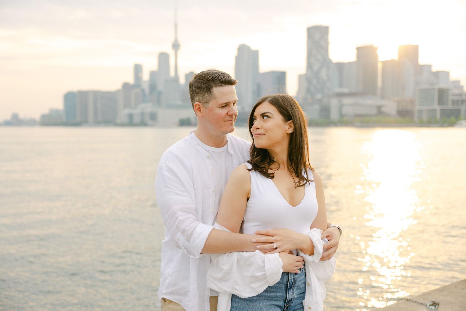 Intimate waterfront moment captured with Toronto's iconic CN Tower and buildings in background.
