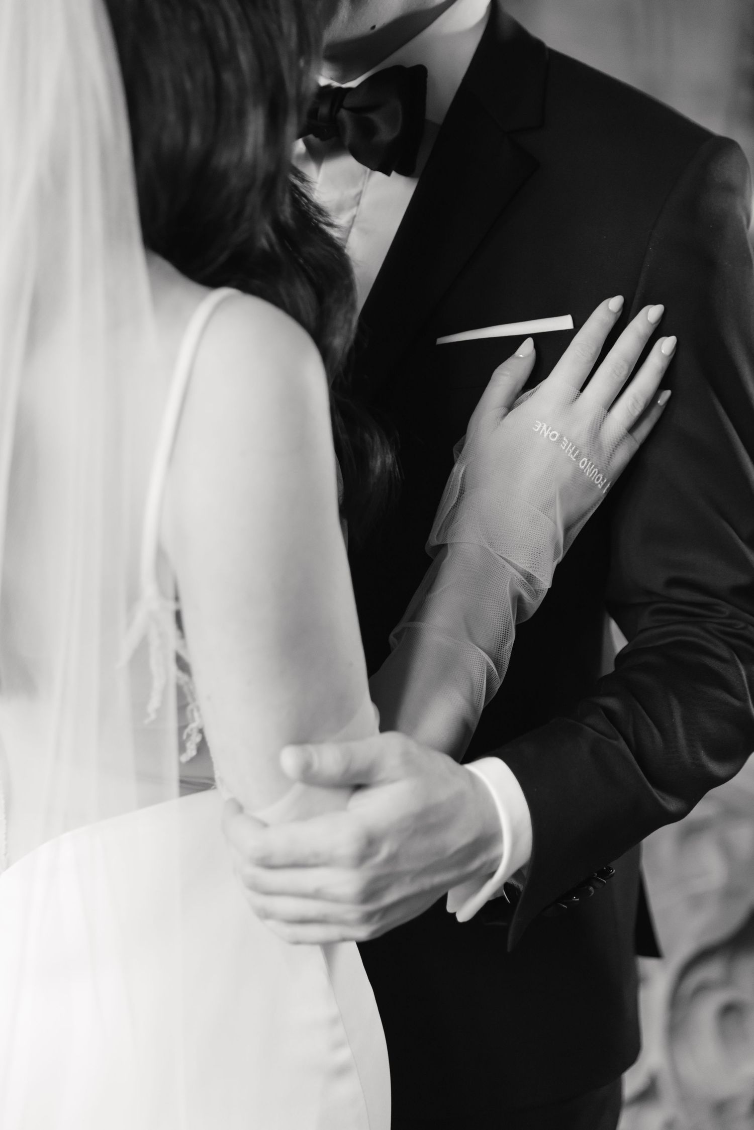 Black and white portrait capturing a tender embrace between newlyweds.