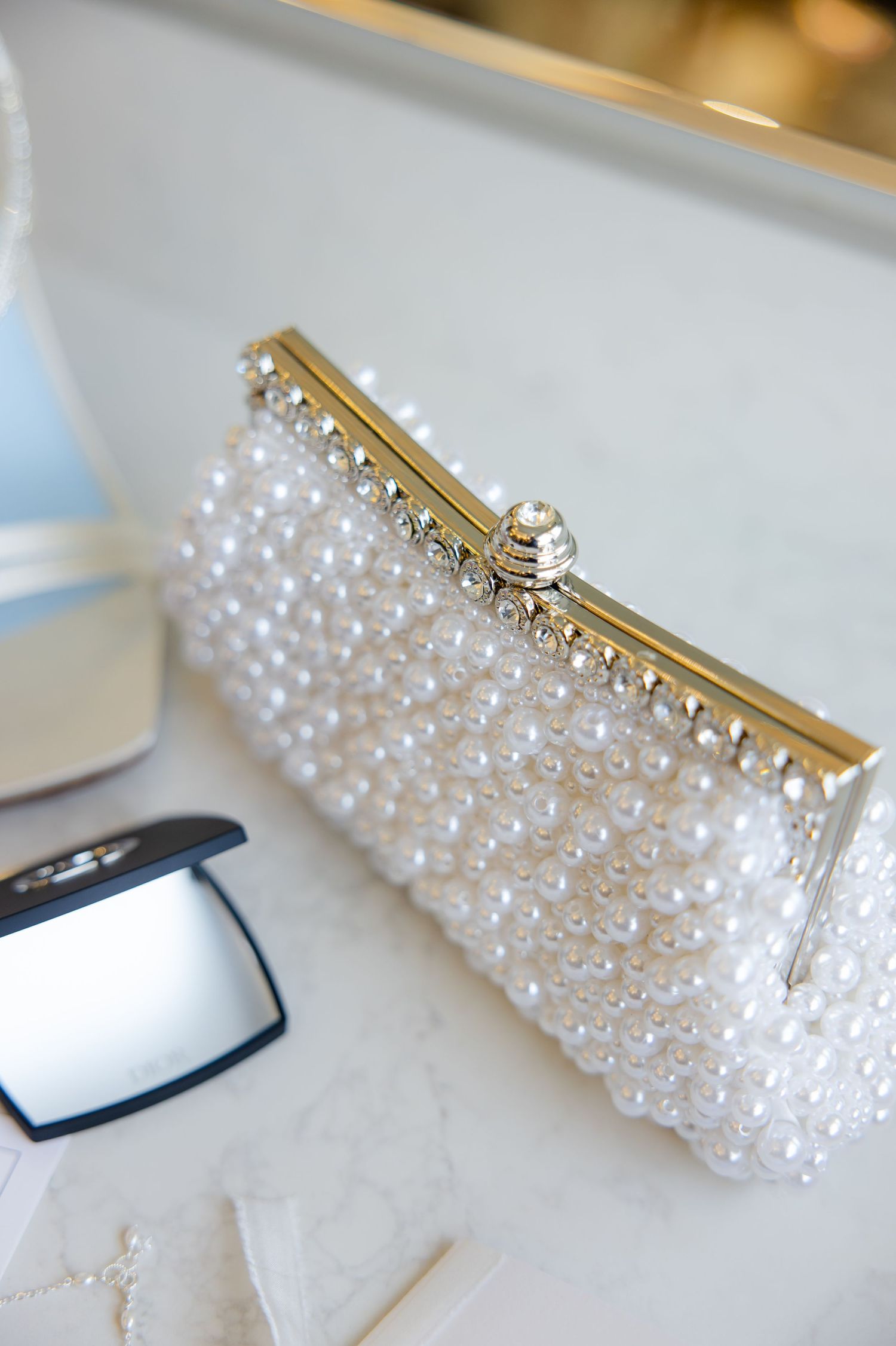 Elegant pearl-encrusted bridal clutch with gold clasp detail.