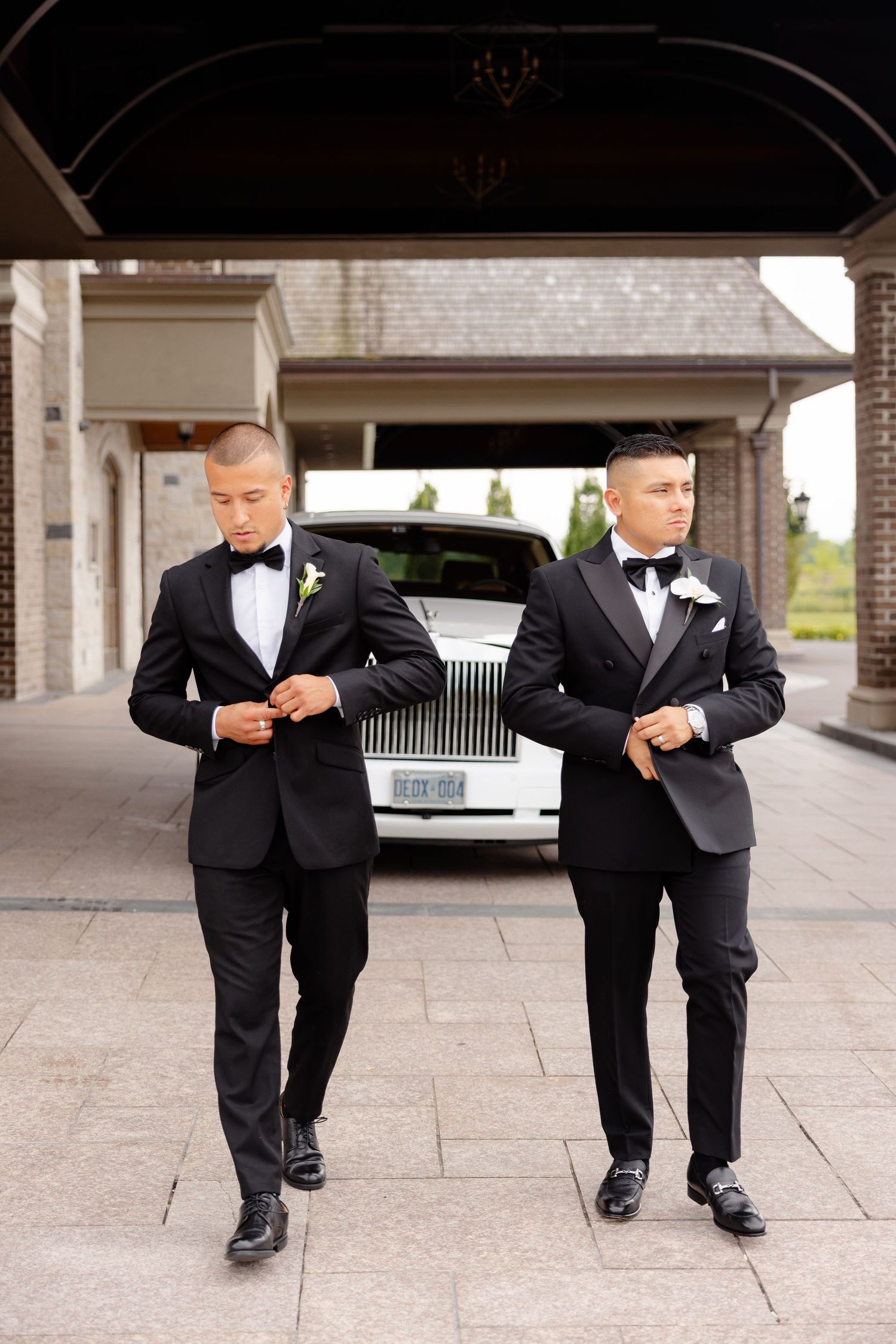 Two people in black tuxedos comparing their shoes in a fun pose sequence during a formal event.