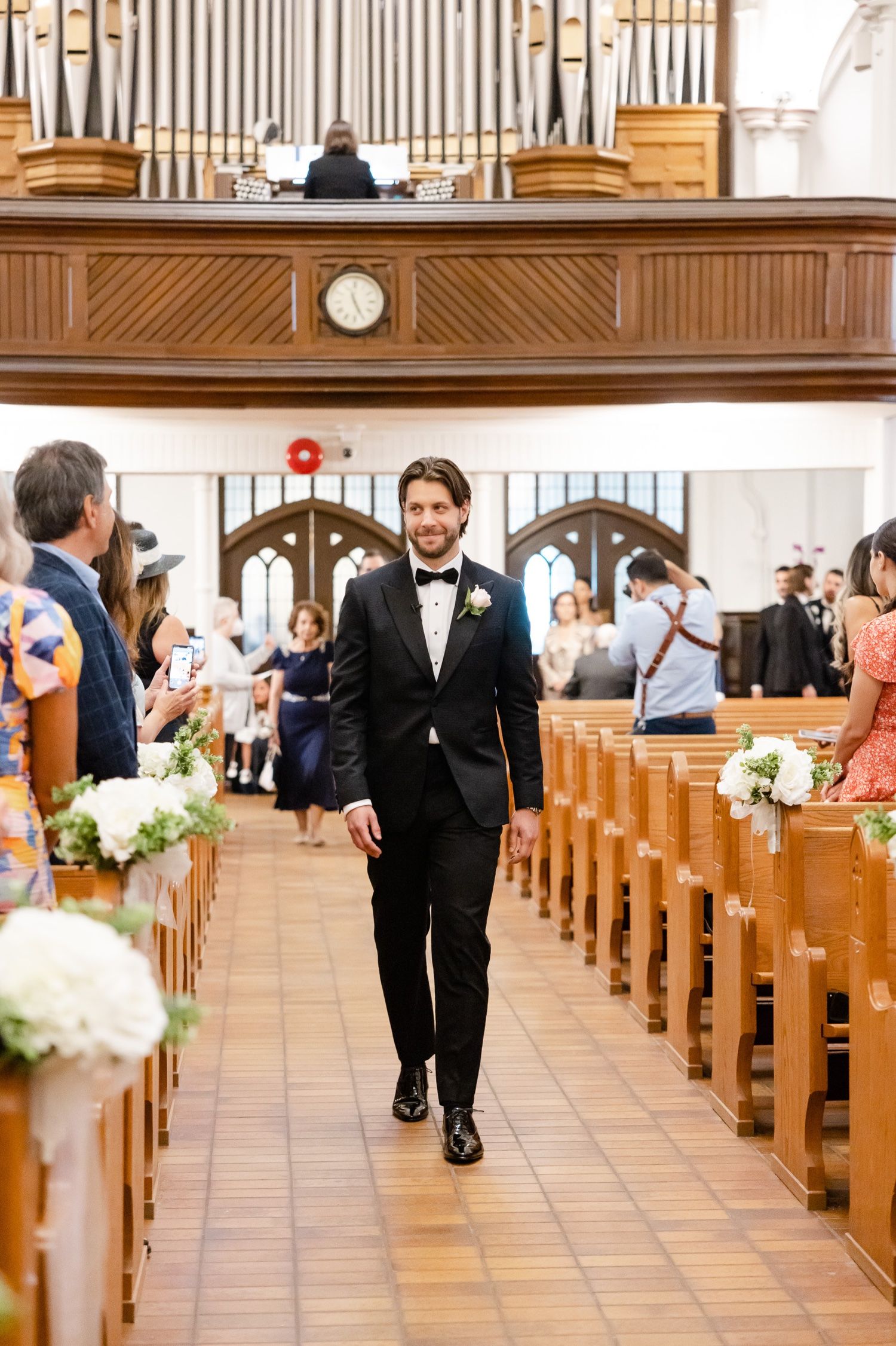 A formal church wedding ceremony with grand pipe organ and traditional wooden pews.