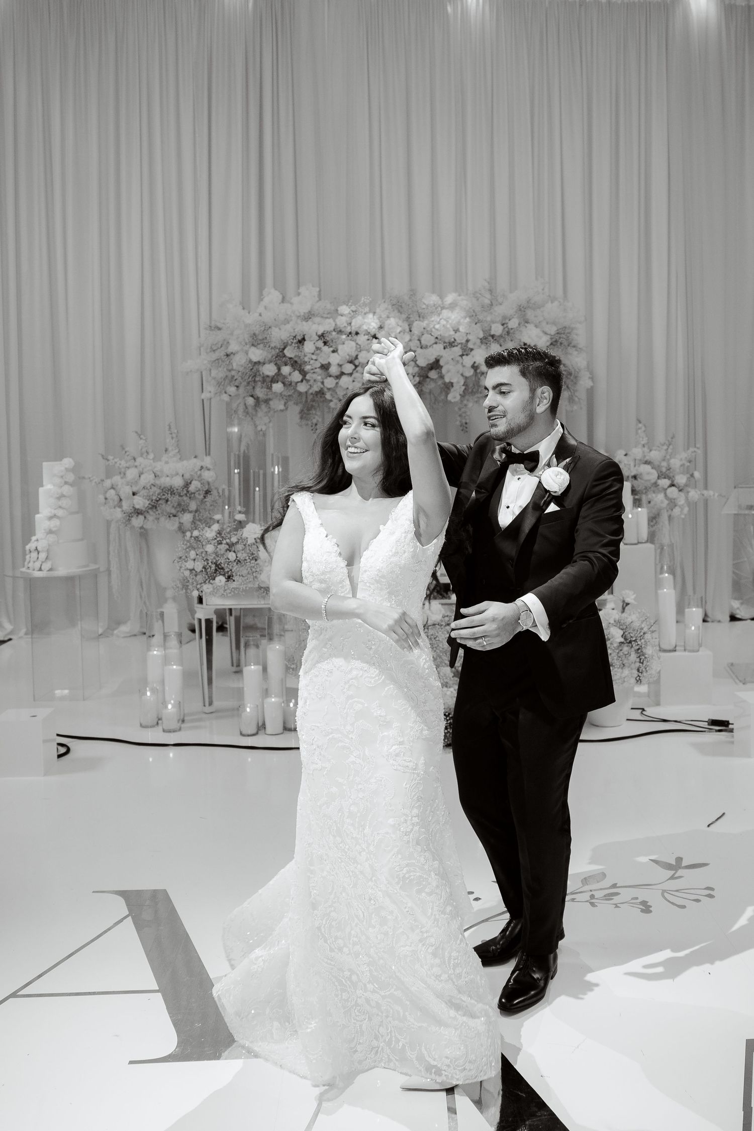 A joyful dancing moment captured in black and white during a wedding celebration.