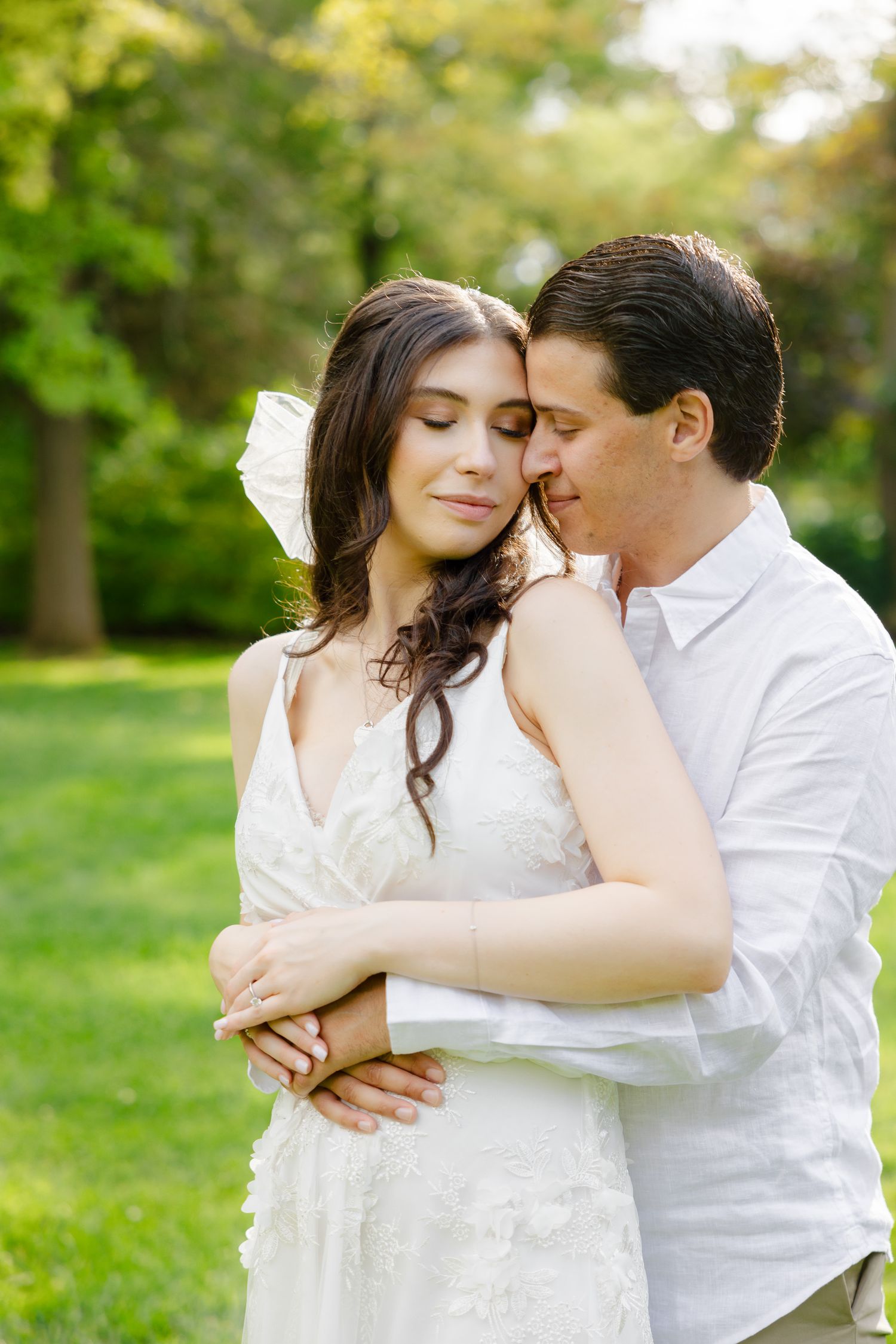 A romantic embrace captured in soft natural lighting with lush garden backdrop.
