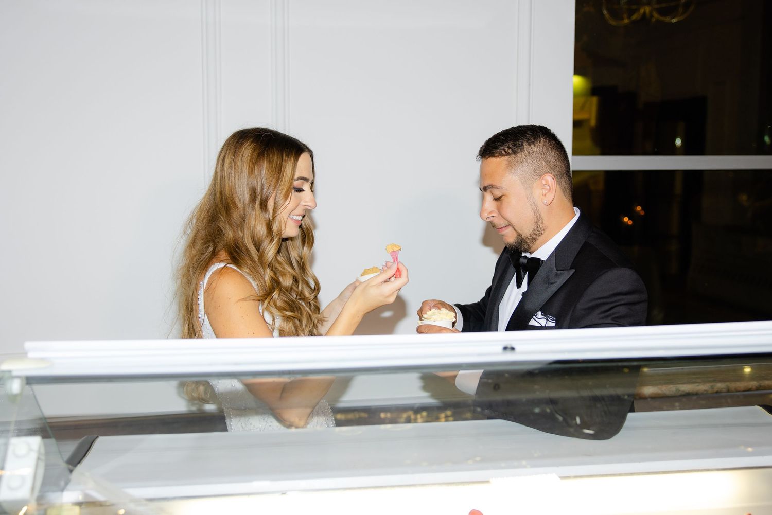 Couple tasting gelato samples together at an elegant dessert station.