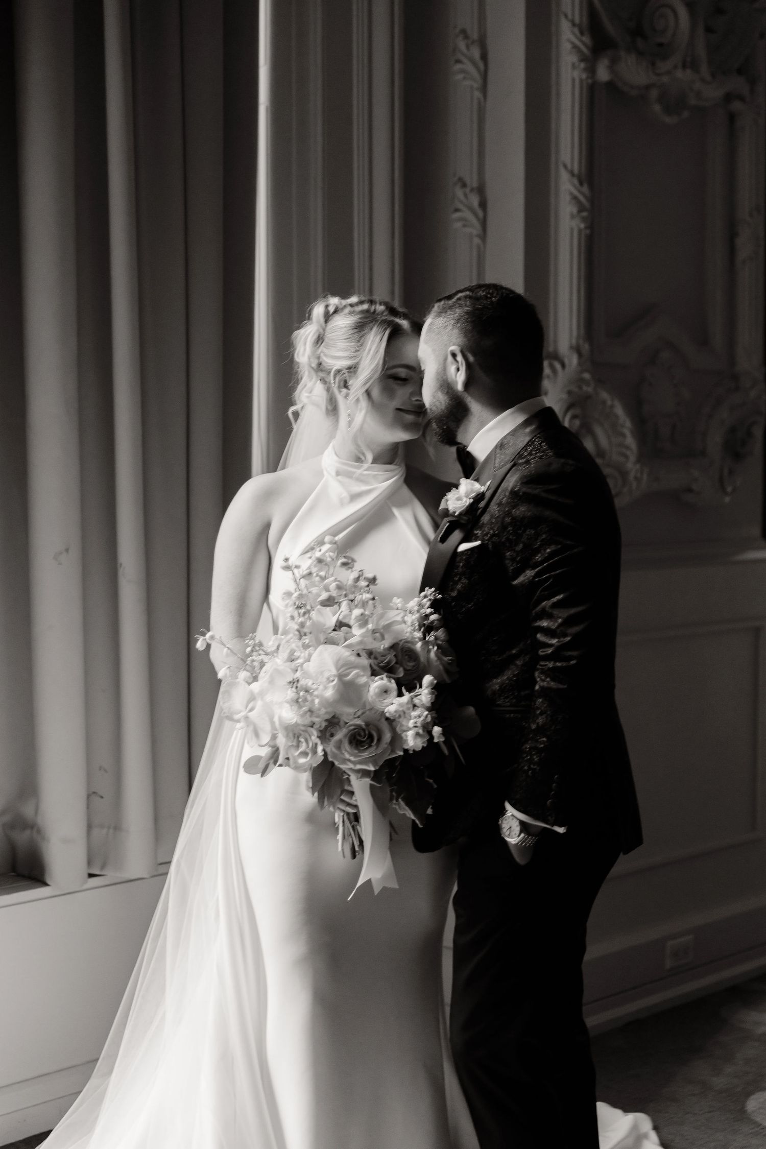 Black and white wedding photos capture emotional first look moments in an elegant venue.