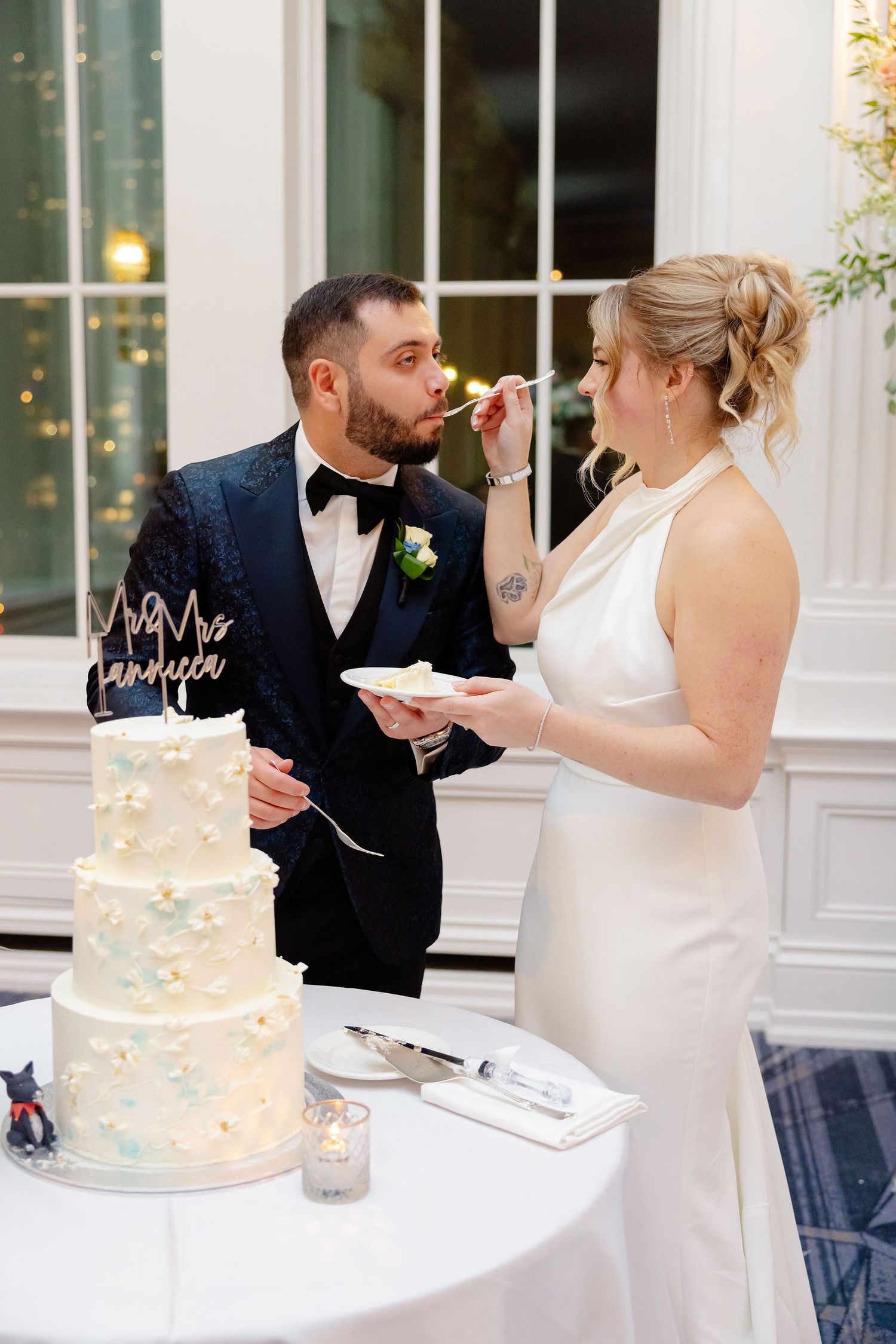 Wedding couple playfully feeds each other cake during their reception cake cutting ceremony.
