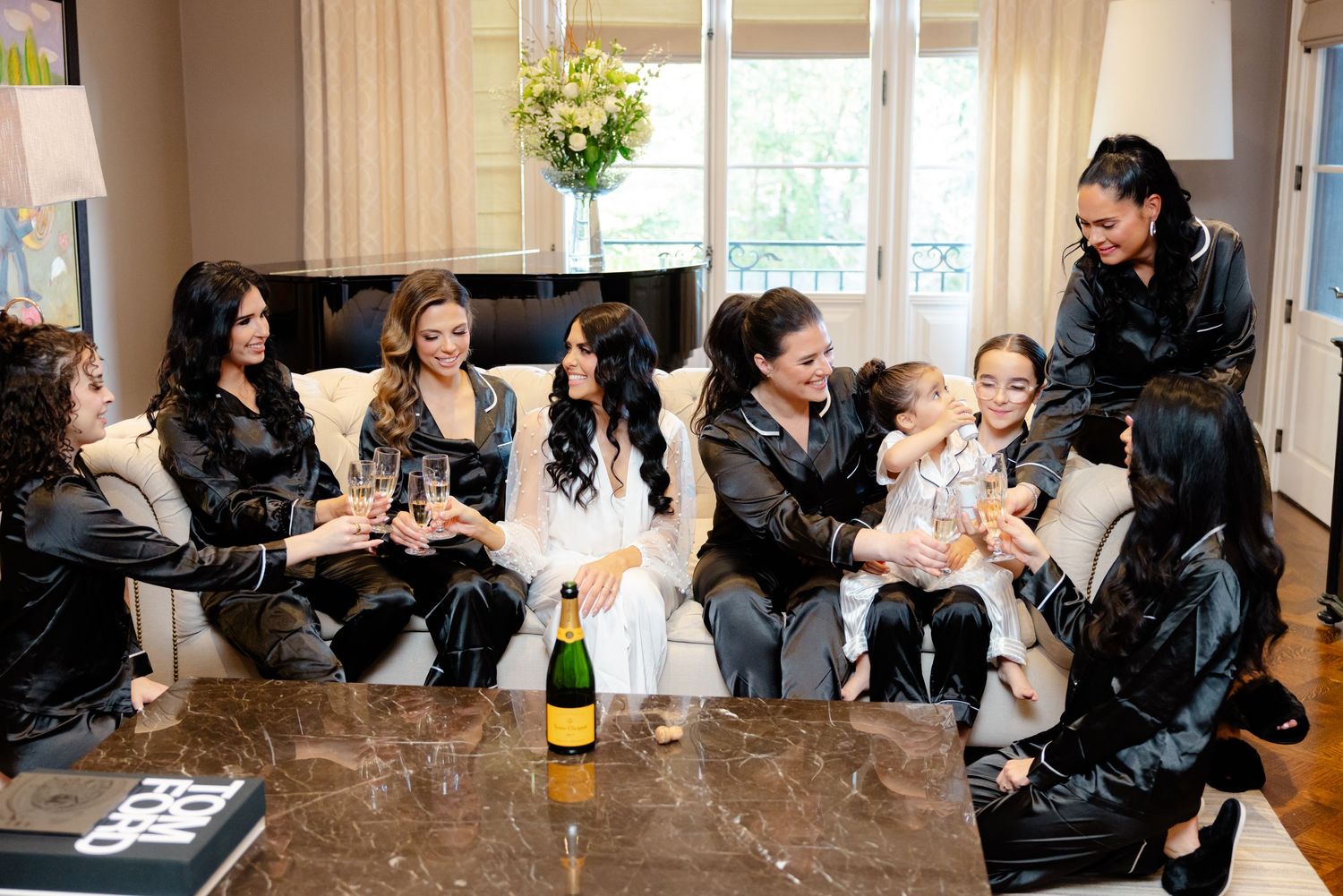Casual moment with bridal party in black robes relaxing and celebrating before the ceremony.