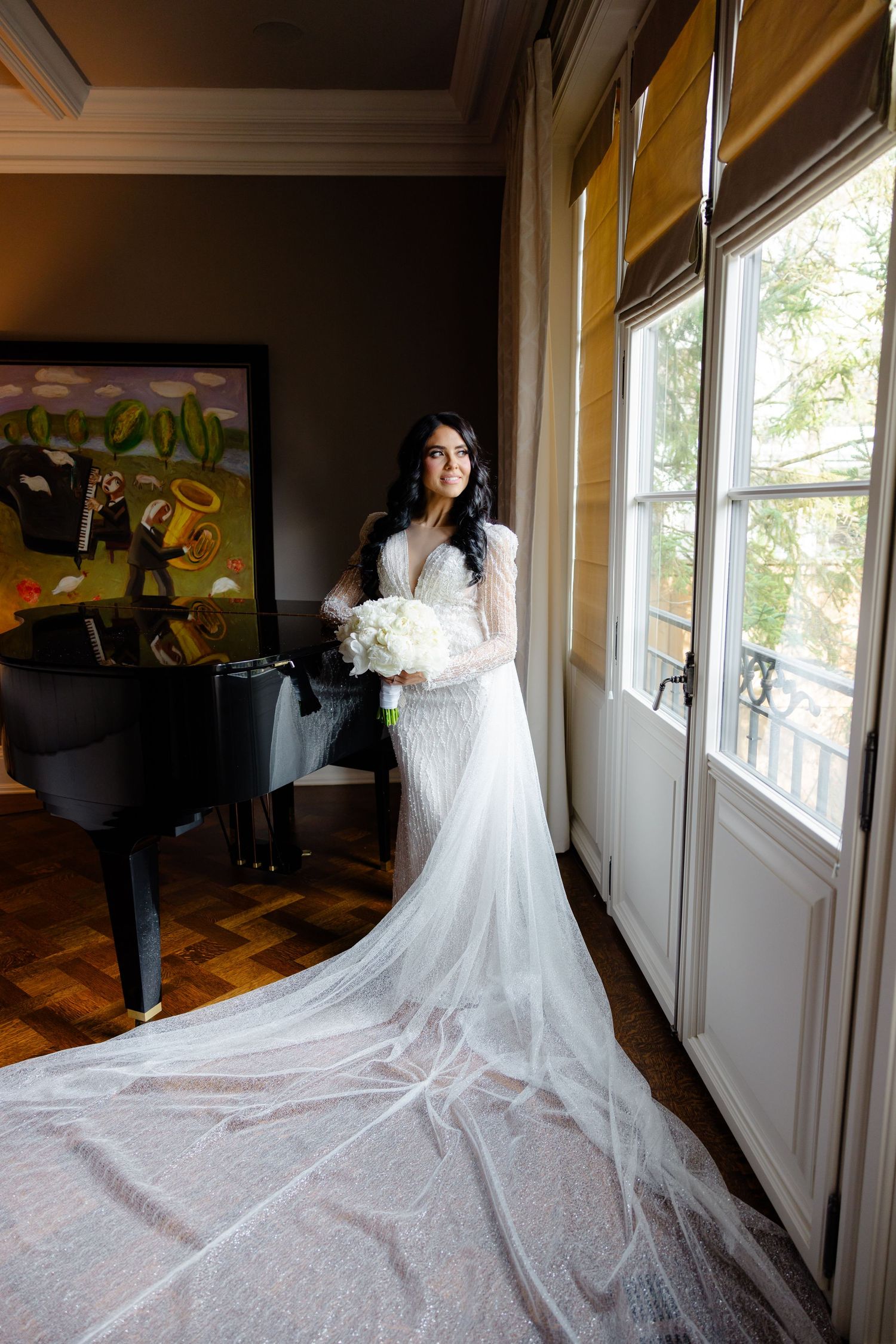 Wedding dress with dramatic cathedral train photographed in elegant room with natural light.