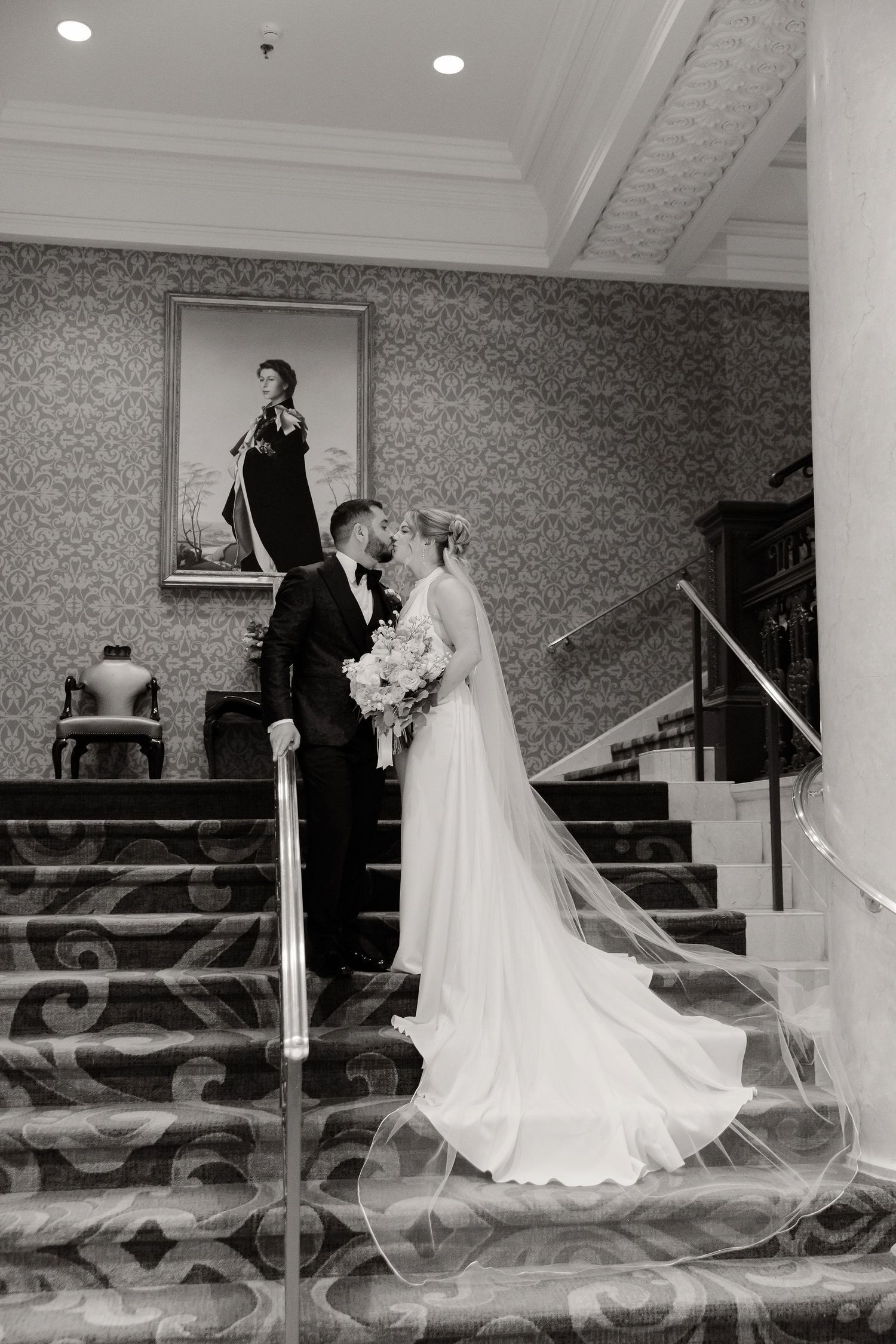 Black and white wedding photo series showing couple on elegant staircase with decorative railings.
