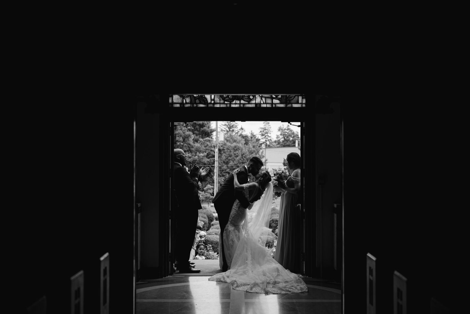 Black and white silhouette of a couple framed in church doorway.