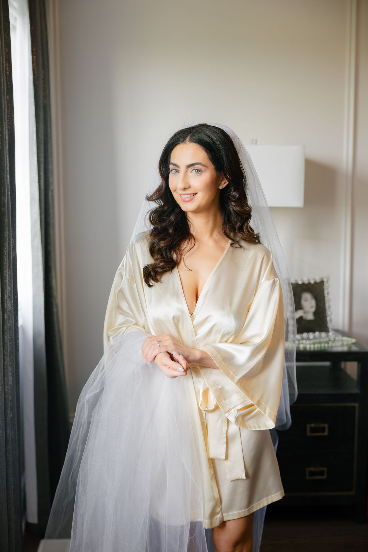Wedding preparation scene with silk robe and flowing white veil.