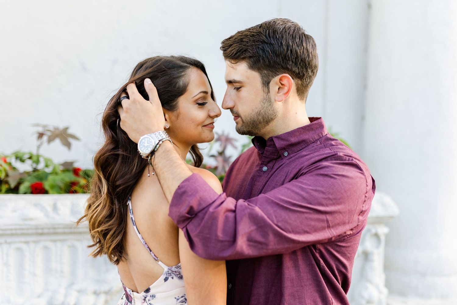 Romantic close-up portrait of couple in purple shirt and floral dress.