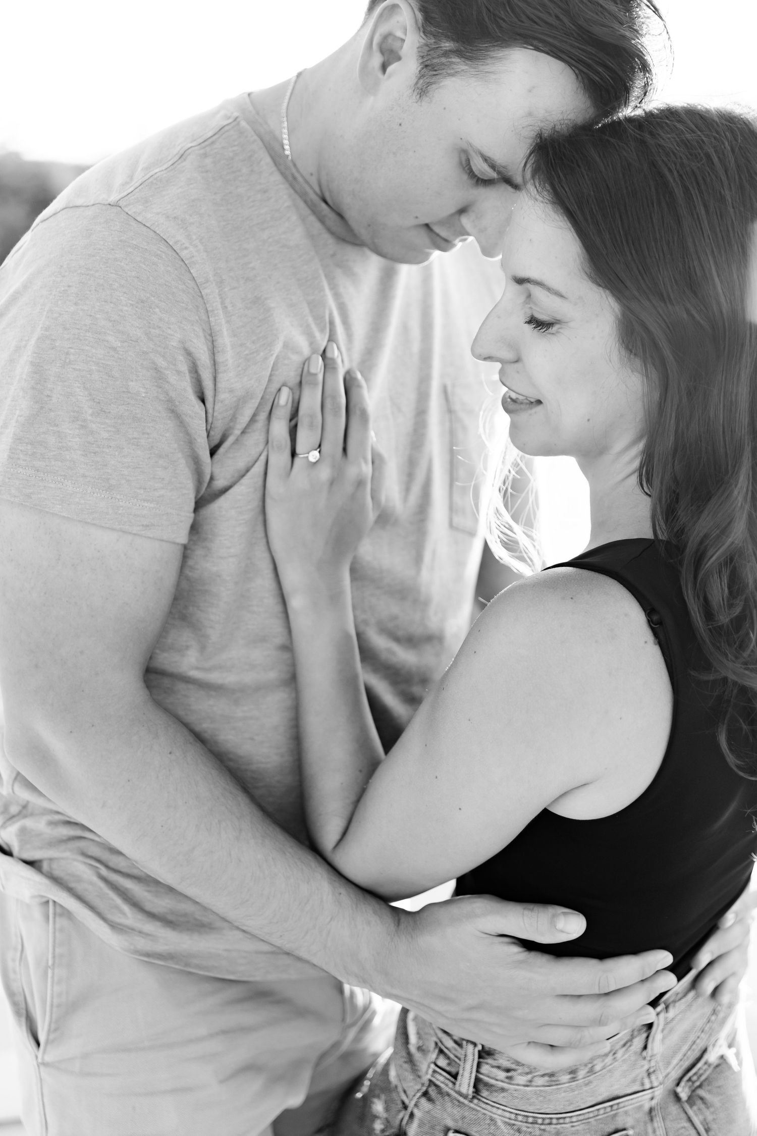 Intimate black and white portrait of couple embracing on boat.