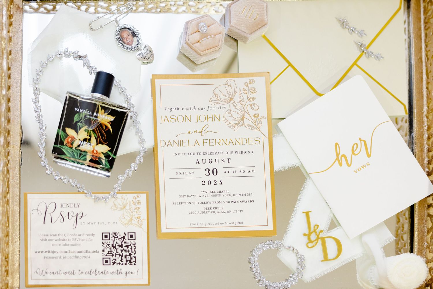 Wedding stationery flat lay with perfume bottle, invitation suite, and crystal accessories.