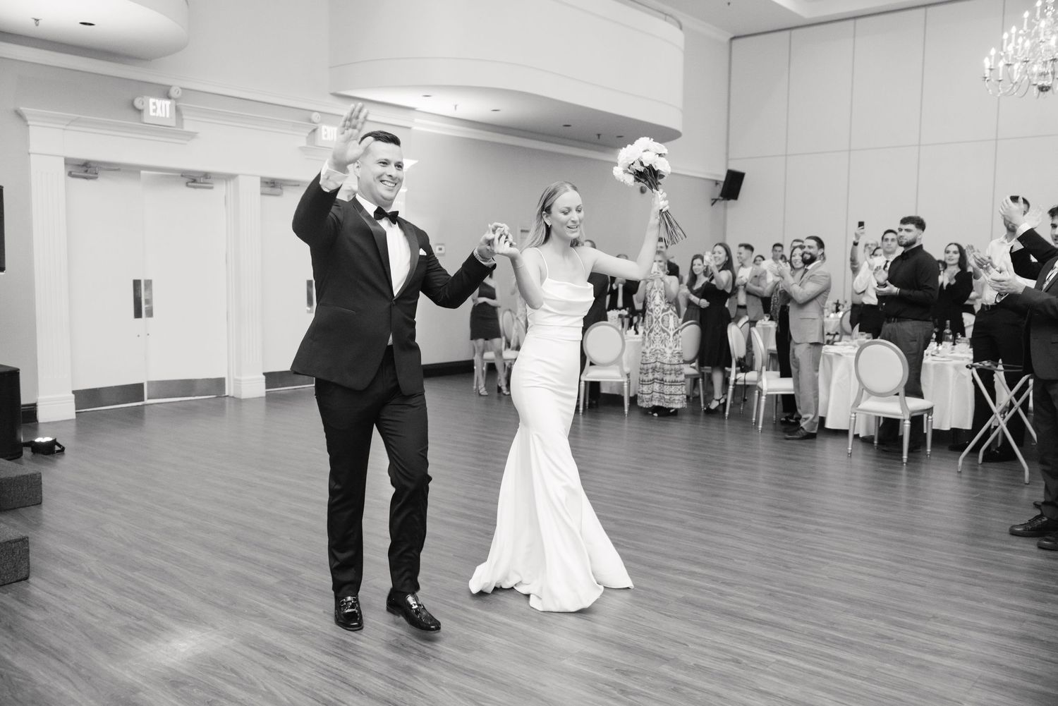 Joyful celebration during first dance at wedding reception with guests watching and applauding.
