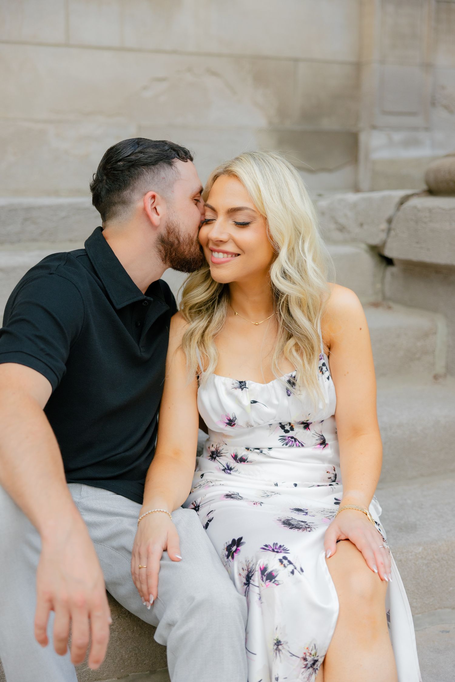 An intimate portrait of a couple sharing a close moment on stone steps.