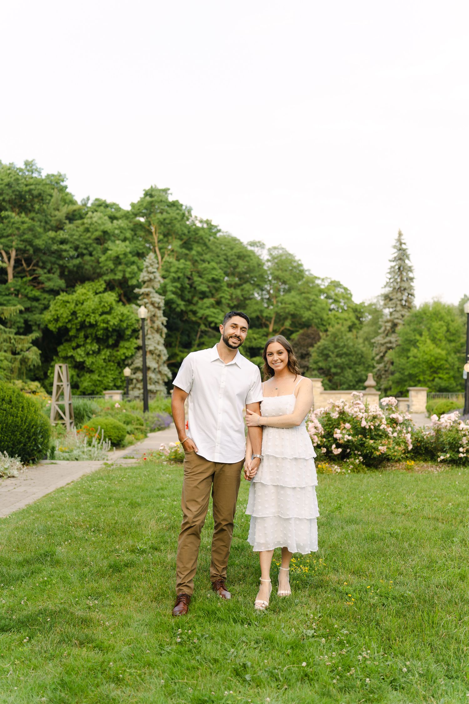 A summer garden portrait with blooming roses and lush greenery in the background.
