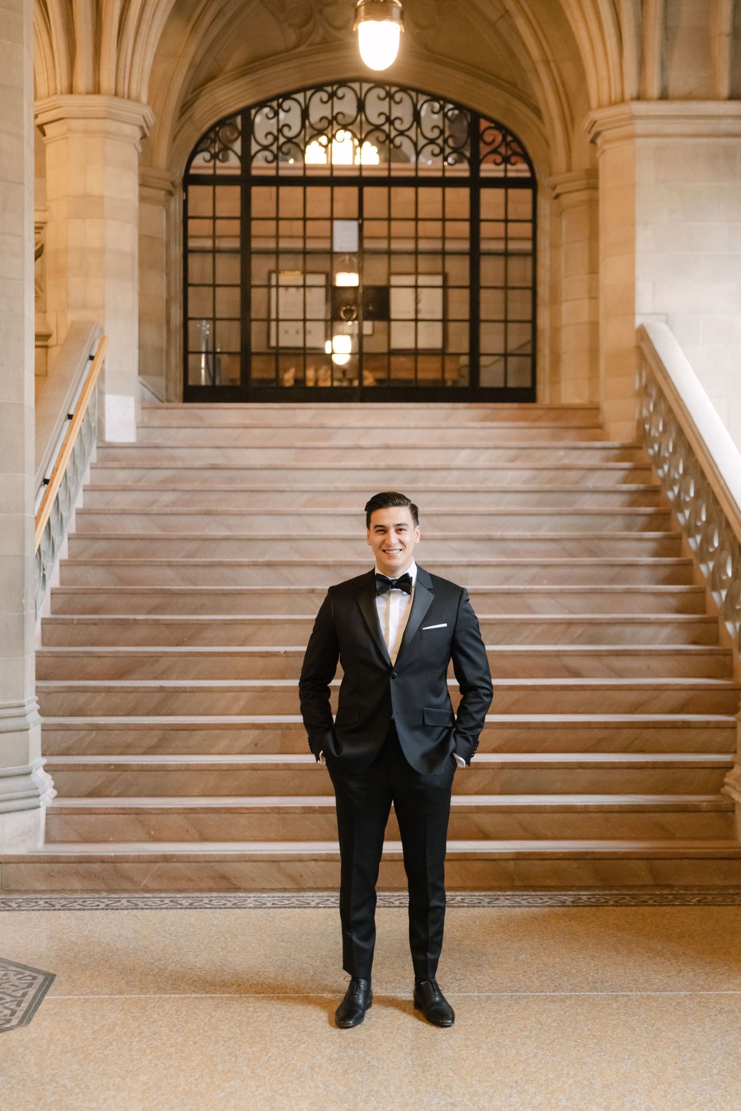 A classic formal portrait showcasing elegant attire against grand architectural stairs and ironwork.