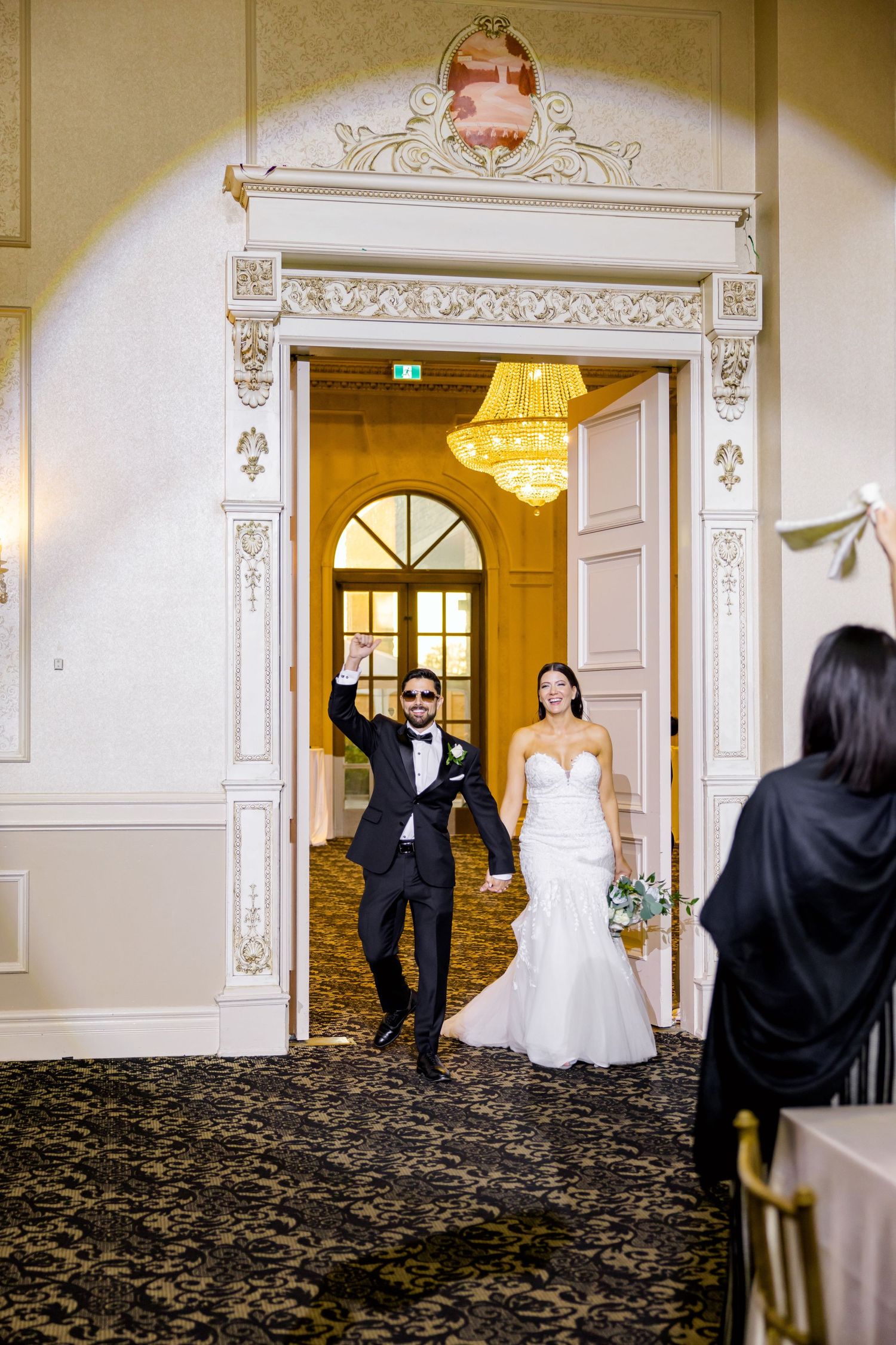 Grand entrance through an ornate doorway at an elegant wedding venue.