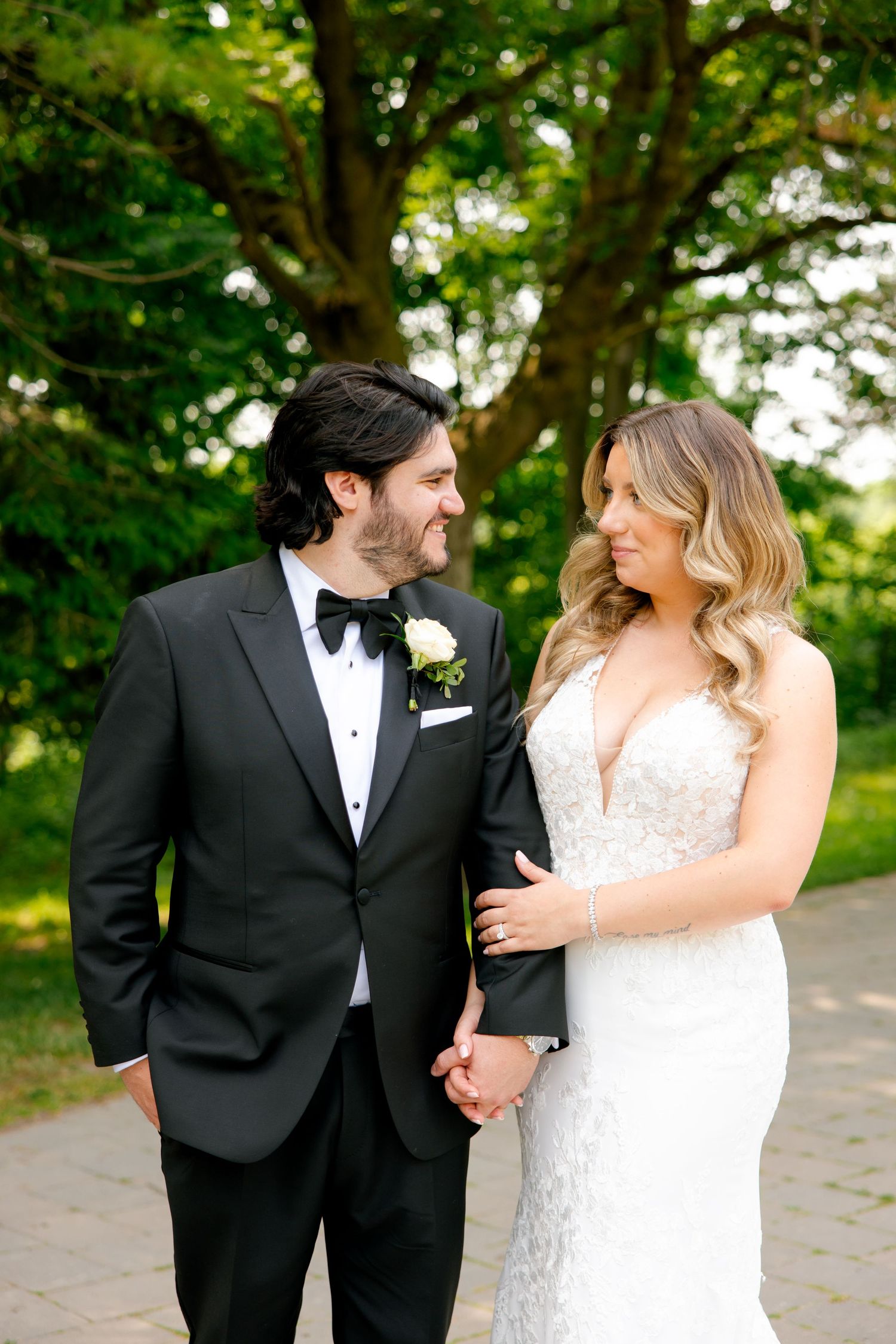 Bride and groom share an intimate moment while posing in a garden setting.