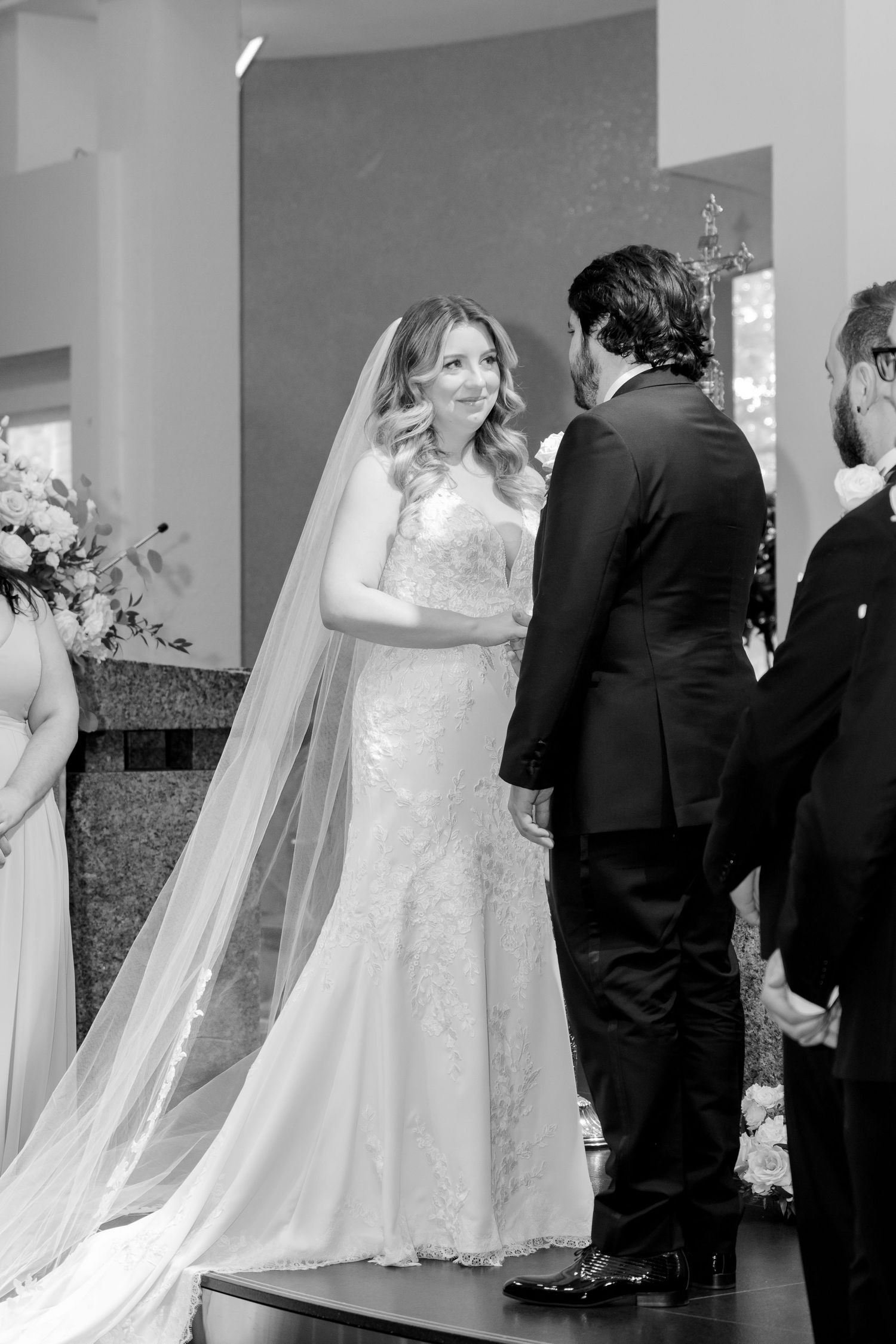 Black and white photo of couple during their wedding ceremony at church altar.