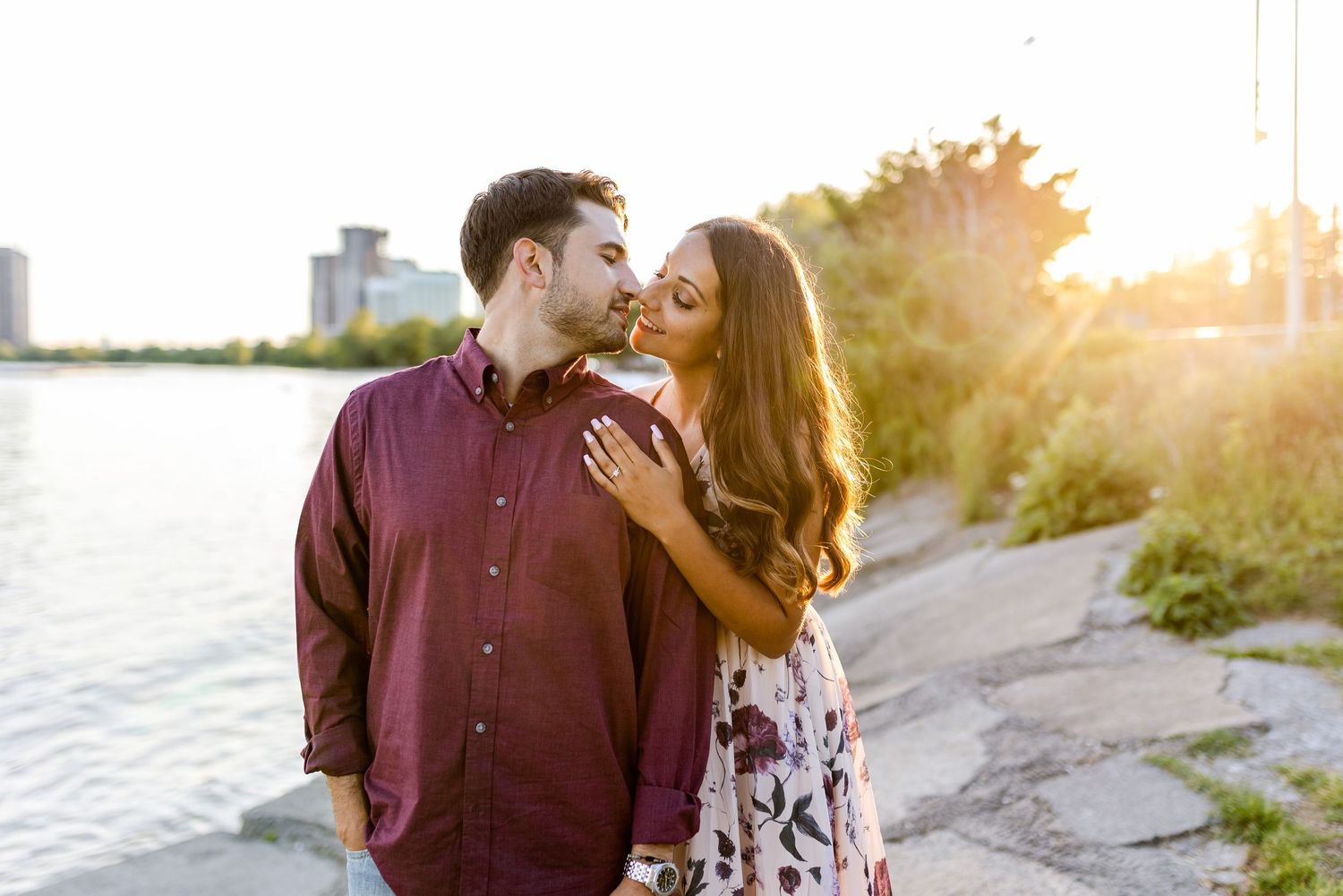 Intimate moment between couple during golden hour photoshoot by the water.