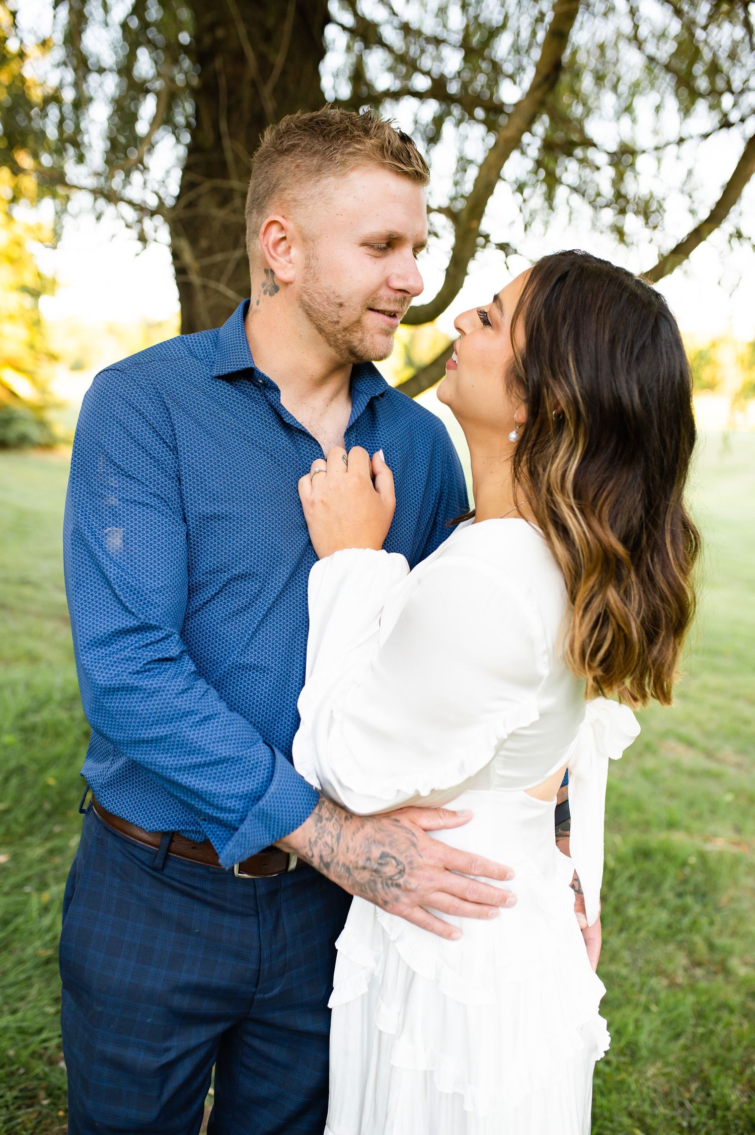A couple shares an intimate moment while dressed in coordinating blue and white outfits.