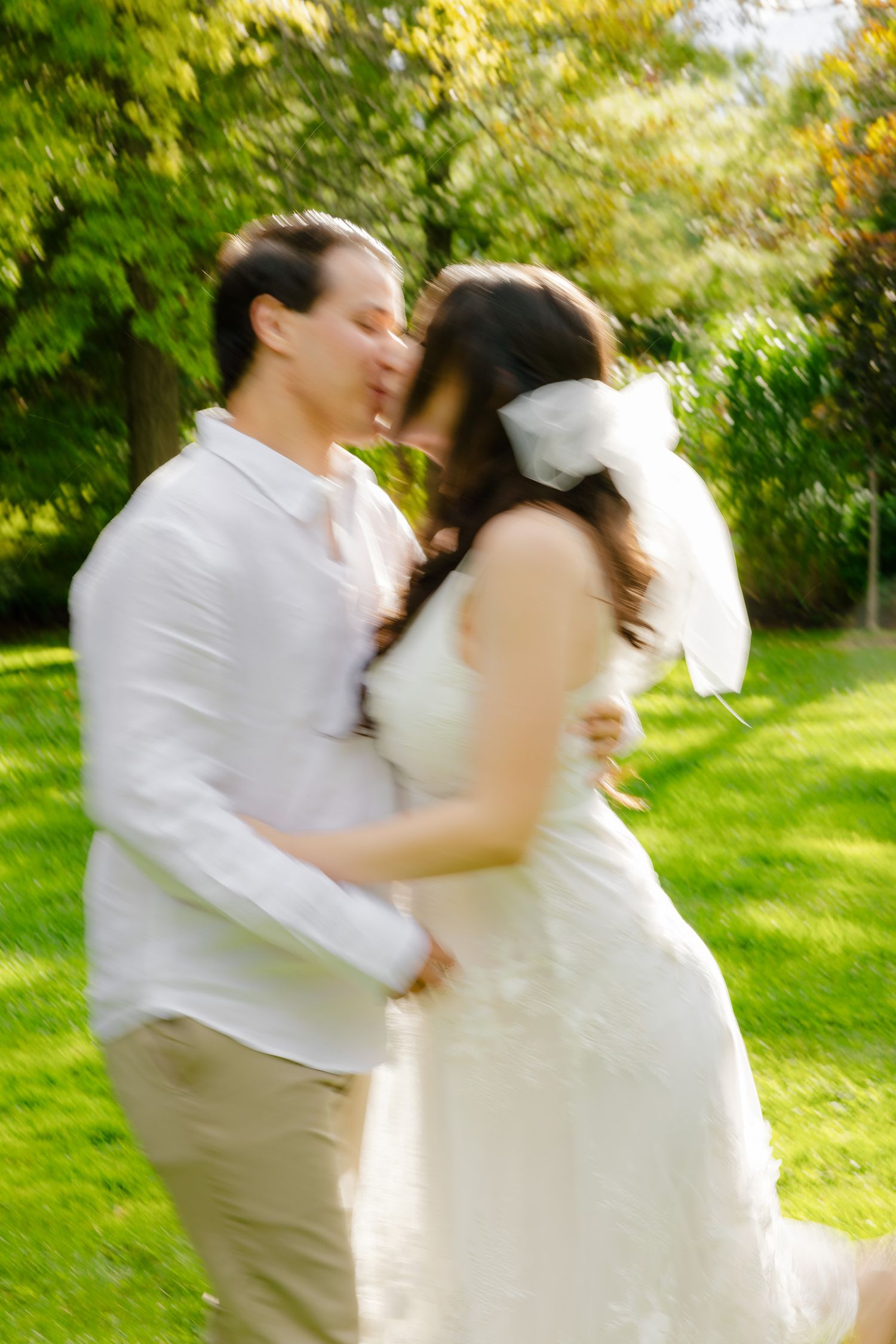 A tender moment between newlyweds captured in a garden with soft, dreamy lighting.