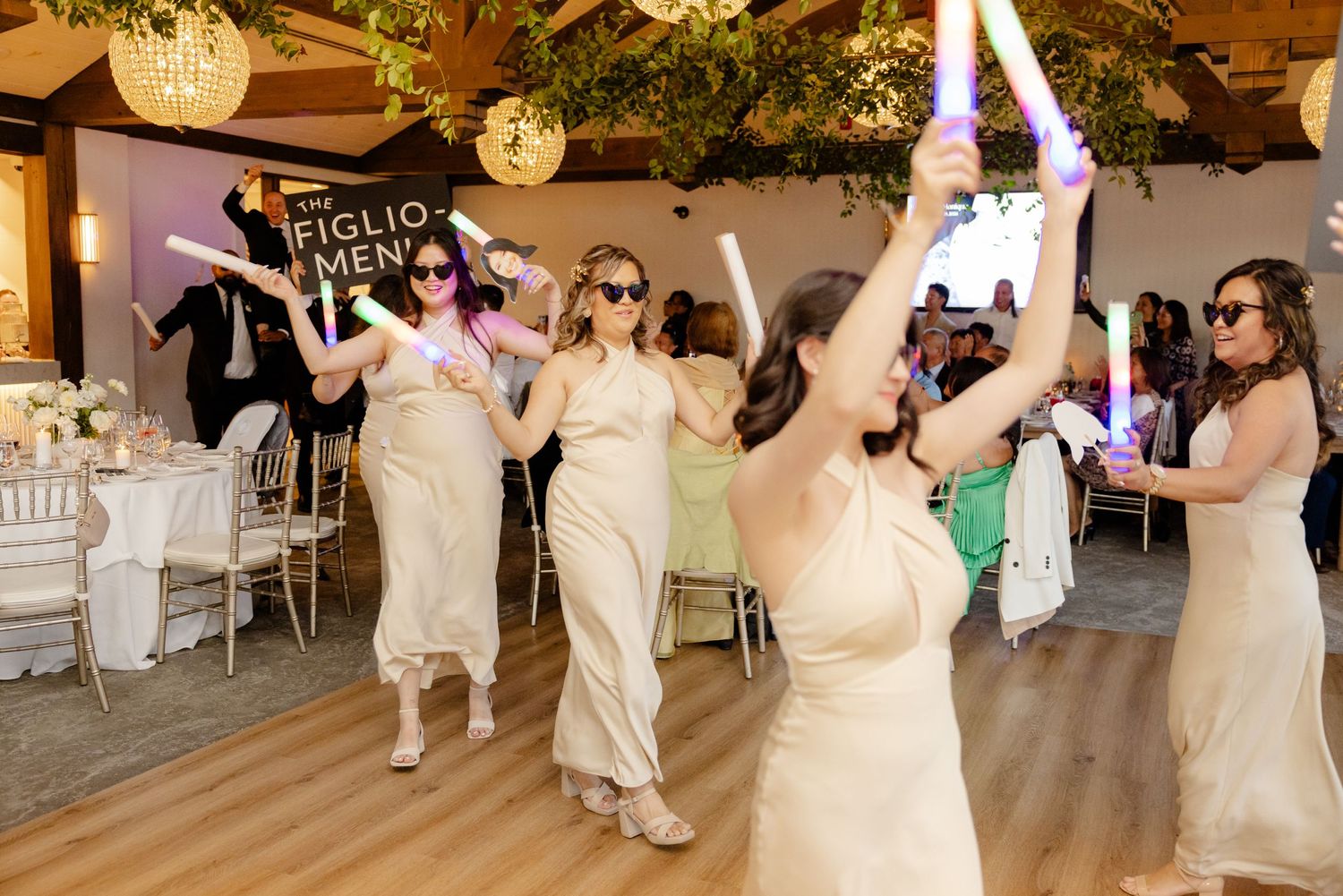 Wedding celebration with coordinated dance moves in a rustic-elegant reception venue.